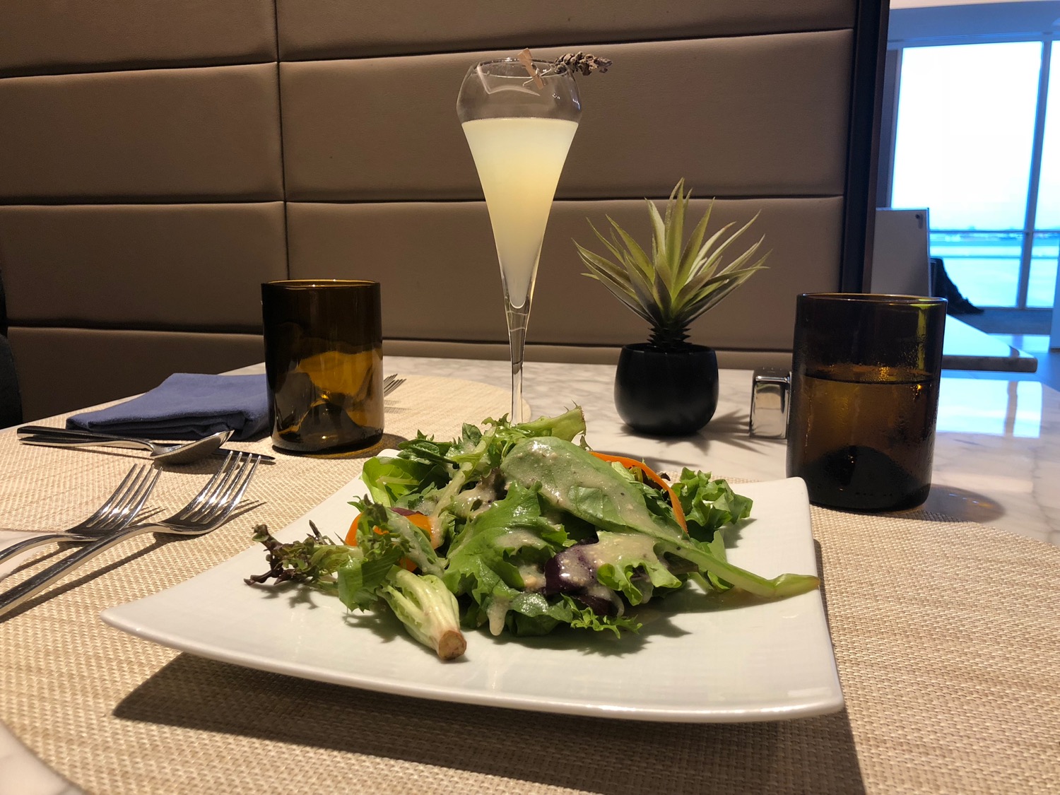 a plate of salad and a glass of liquid on a table