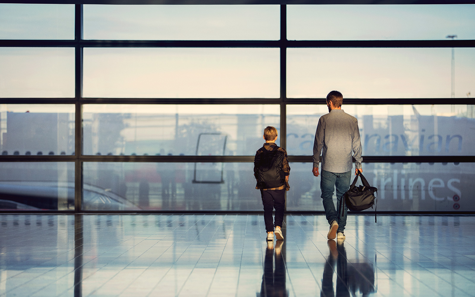 a man and child walking in an airport