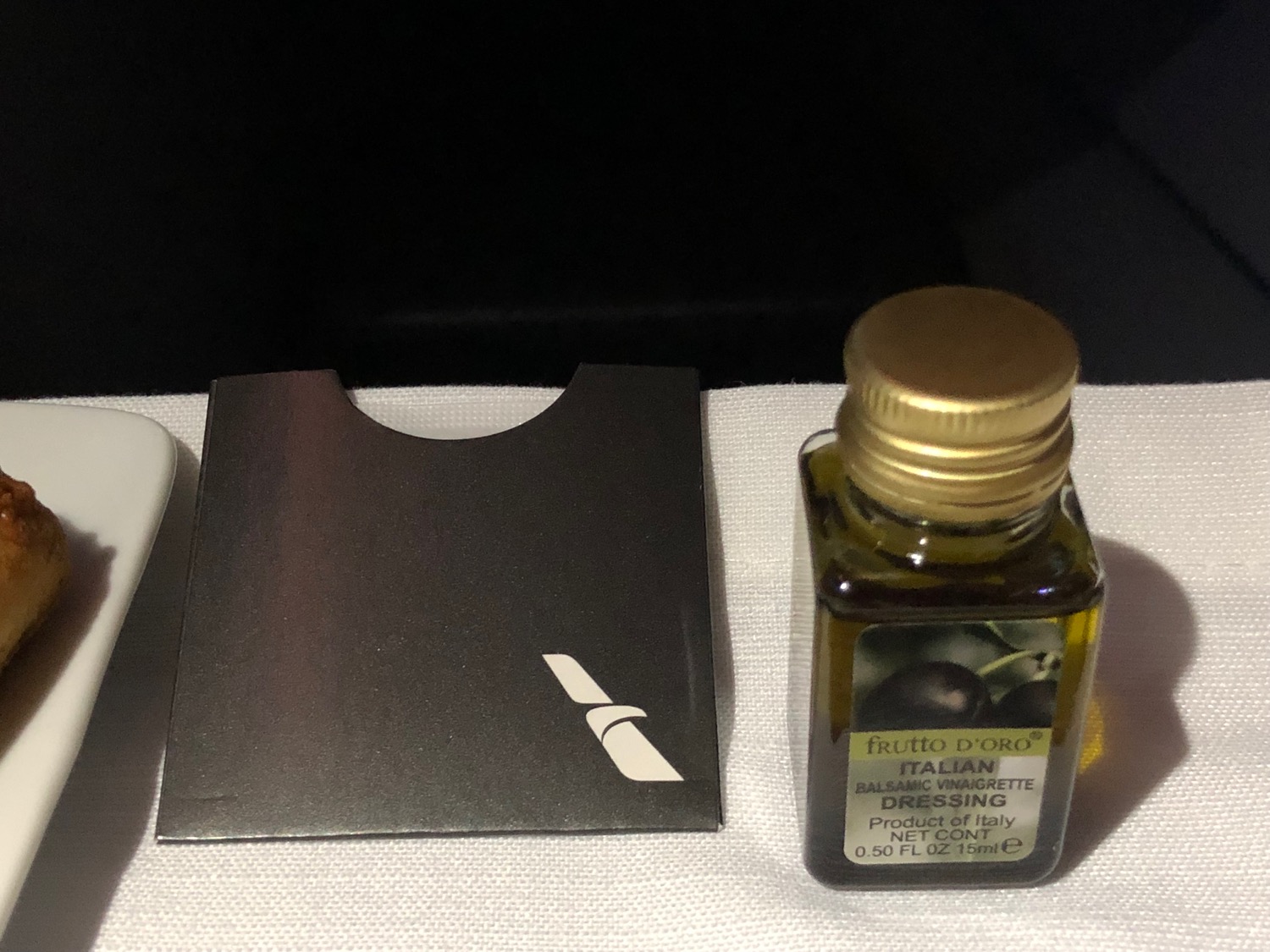 a small bottle of olive oil next to a black bag