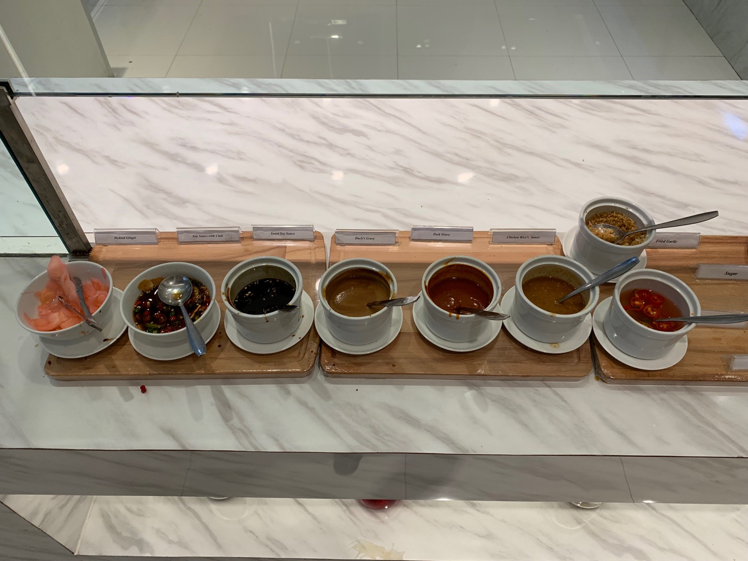 a row of bowls of sauces on a table