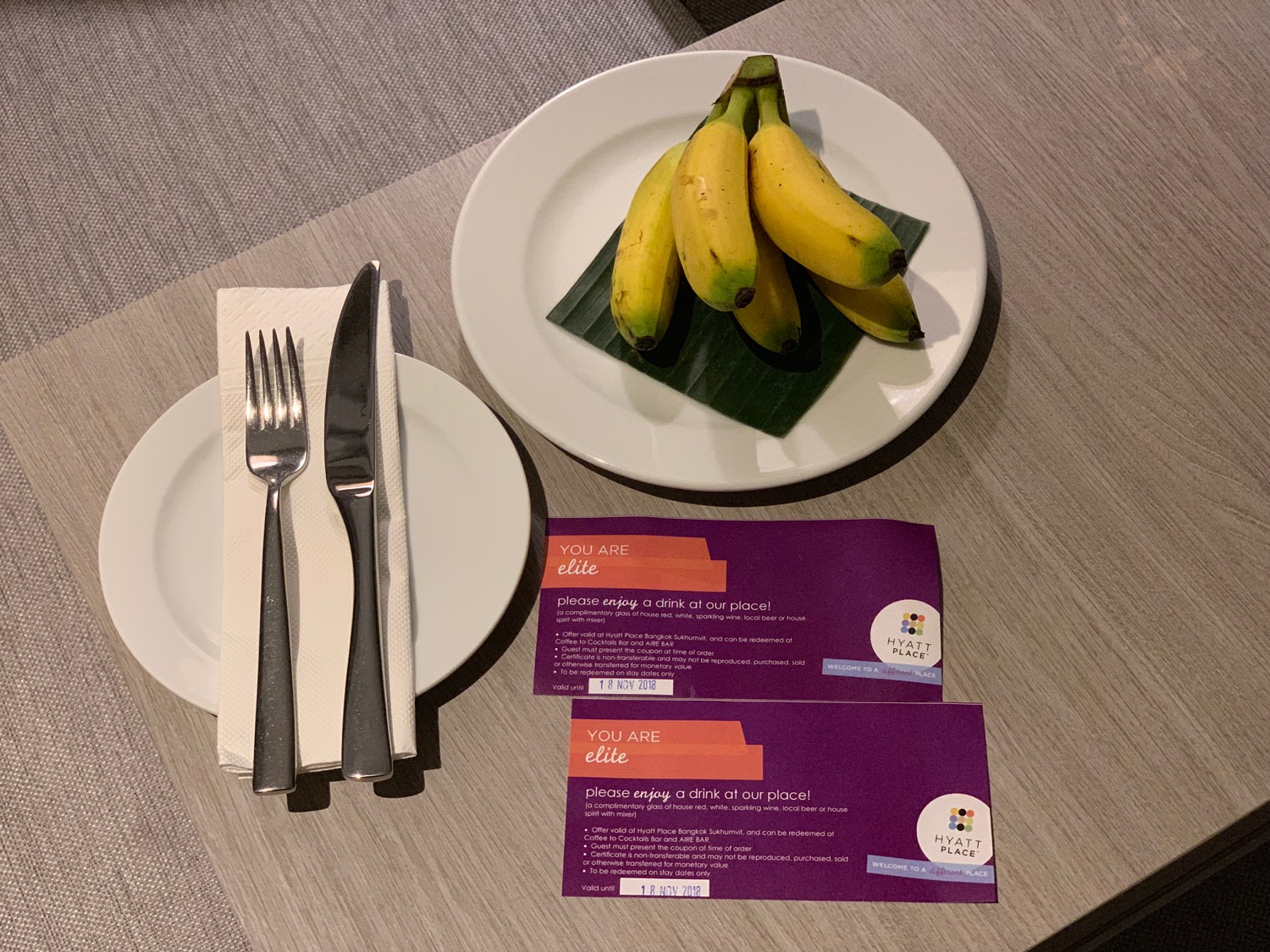 a plate of bananas and a fork and knife on a table