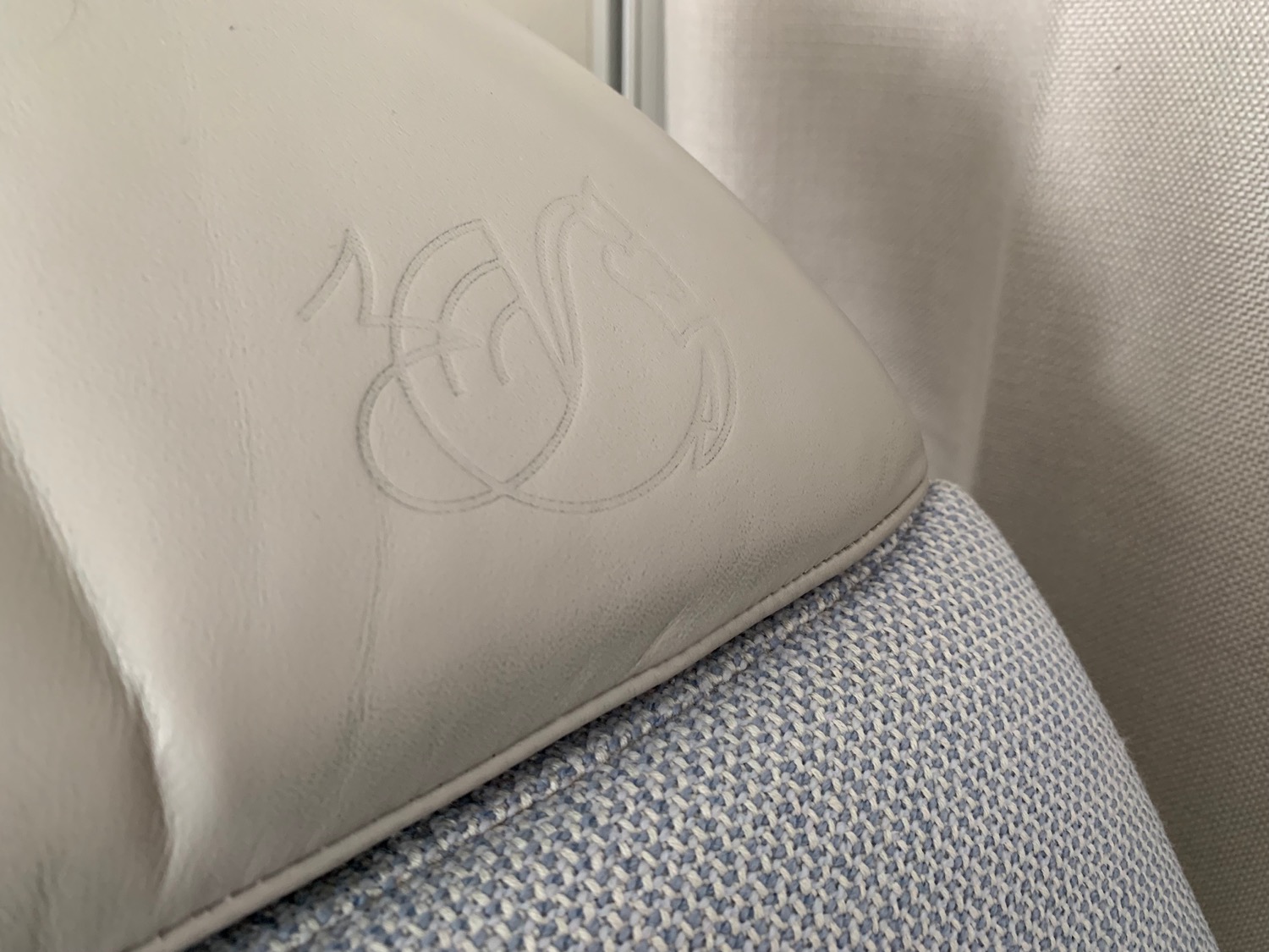 a white leather cushion with a swan design