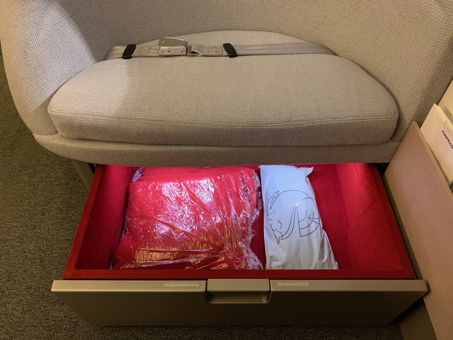 a seat with a seat open with a red and white bag inside