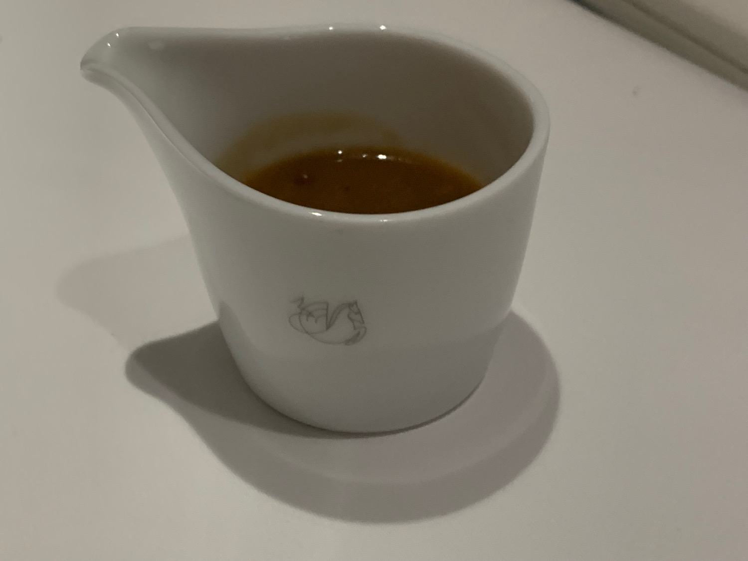 a white cup with brown liquid in it