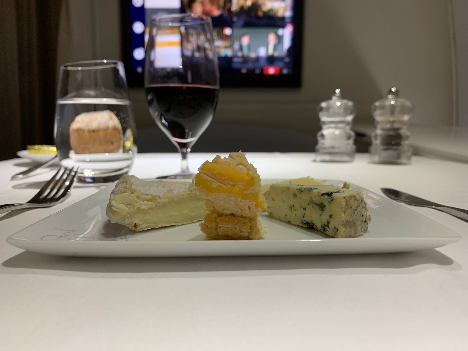 a plate of cheese and wine on a table