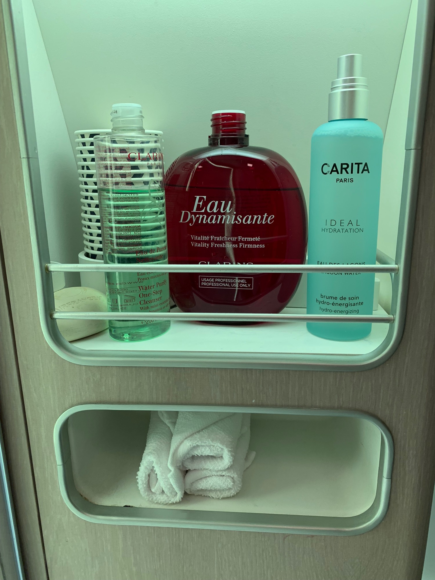 a shelf with bottles and towels
