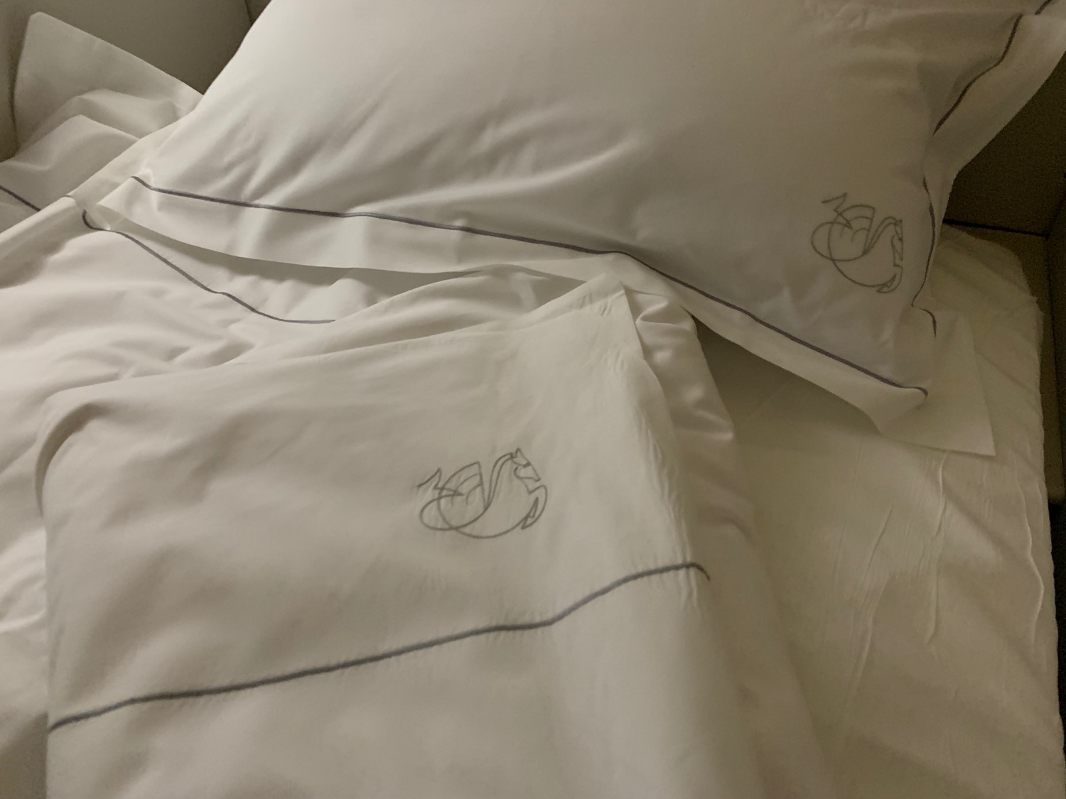 a white pillow with a swan design on it