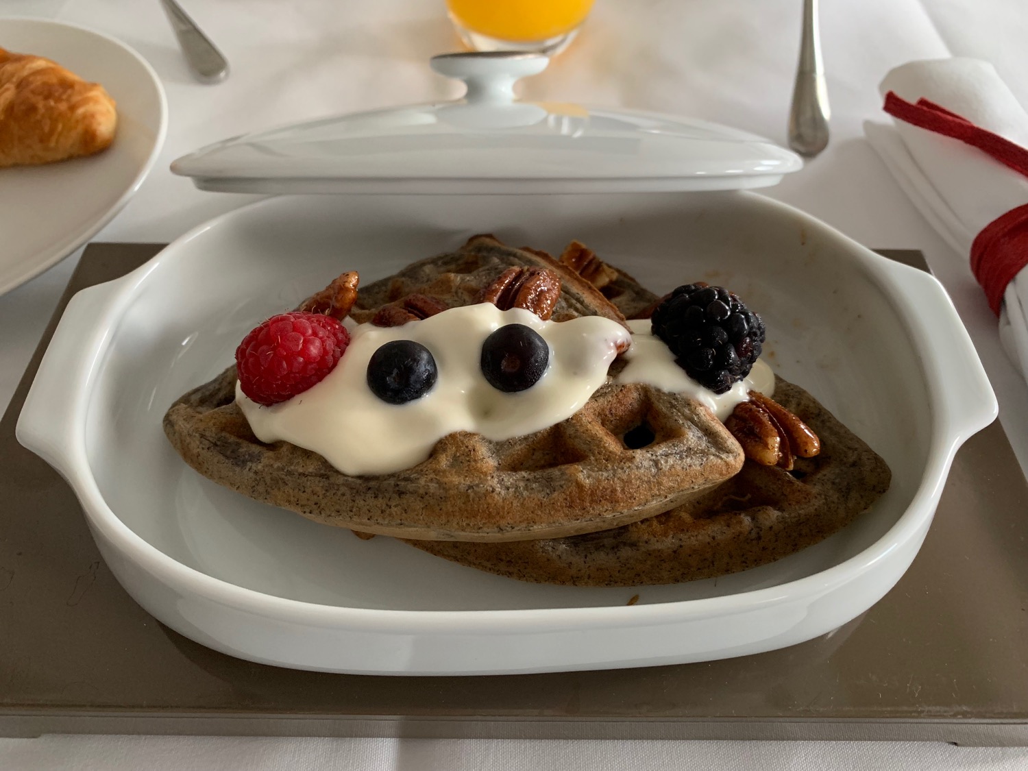 a plate of waffles with fruit and nuts