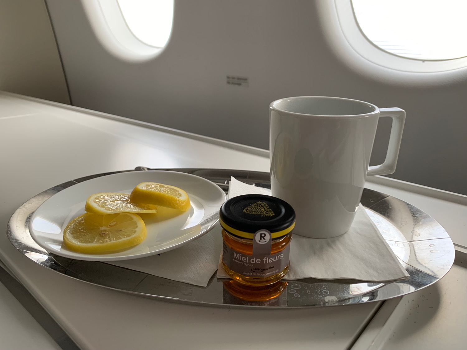 a plate of lemons and a cup of honey on a tray
