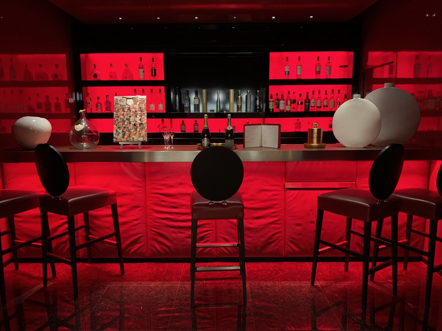 a bar with red shelves and chairs