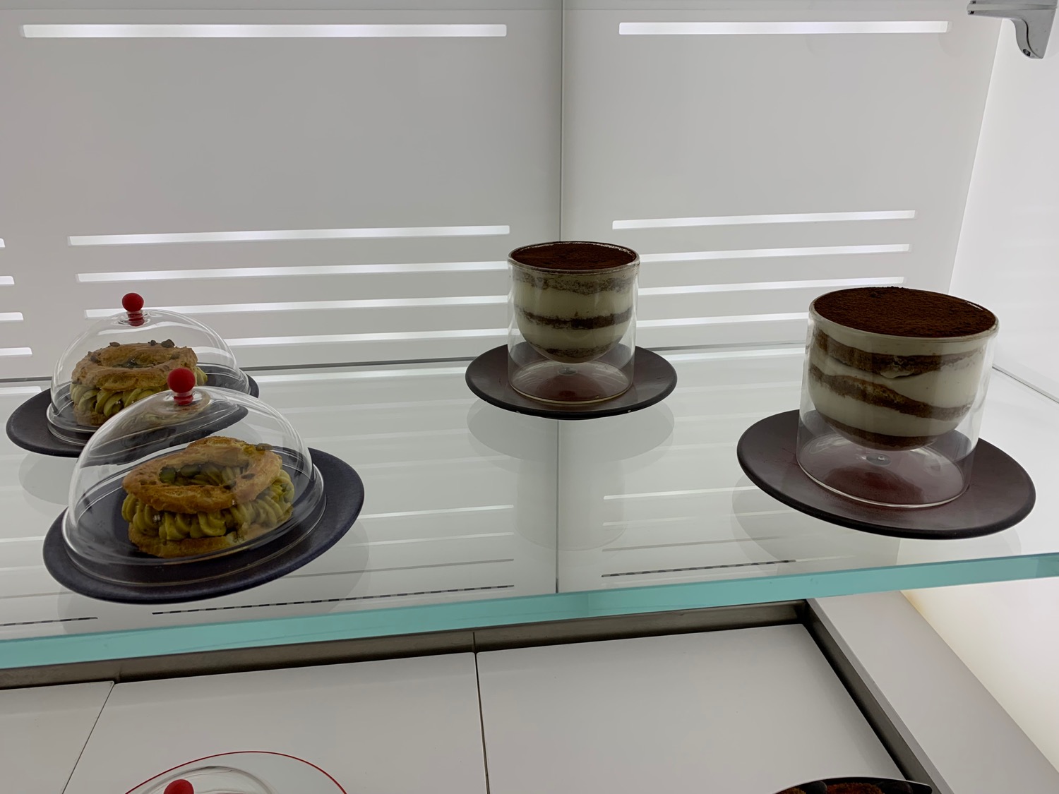 a group of desserts on a glass shelf