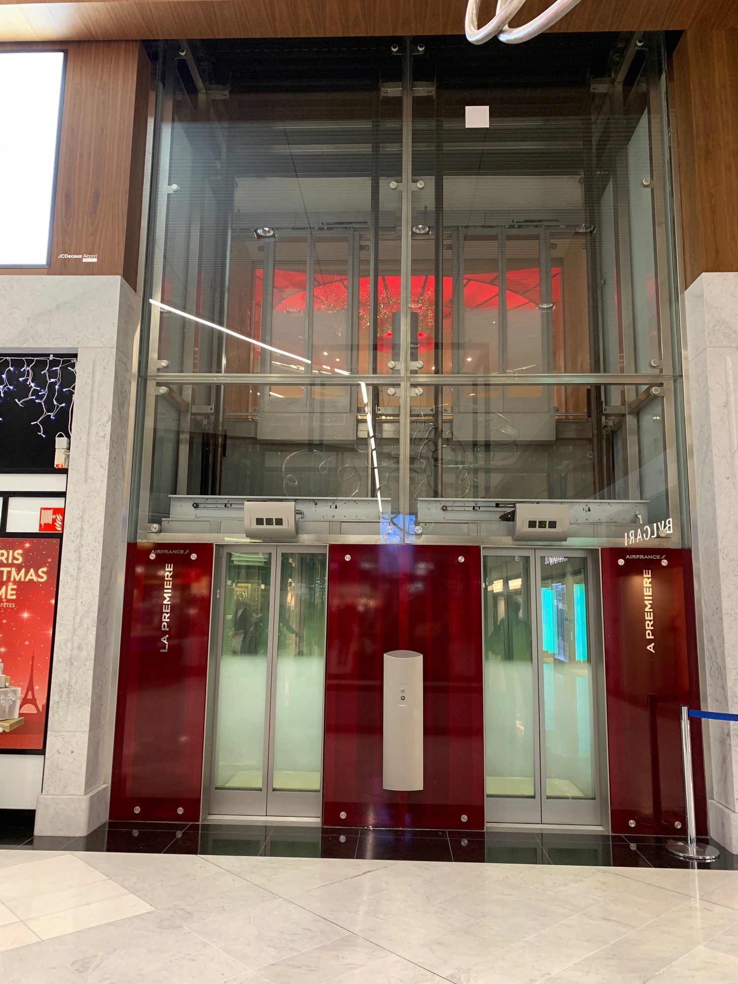 a glass elevator with red doors