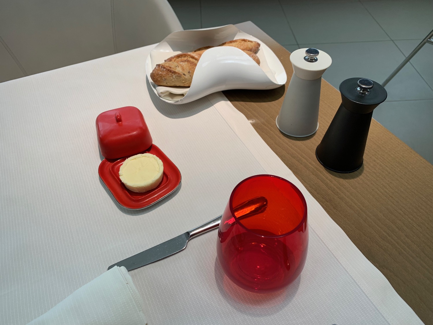 a table with a red container and a red glass on it