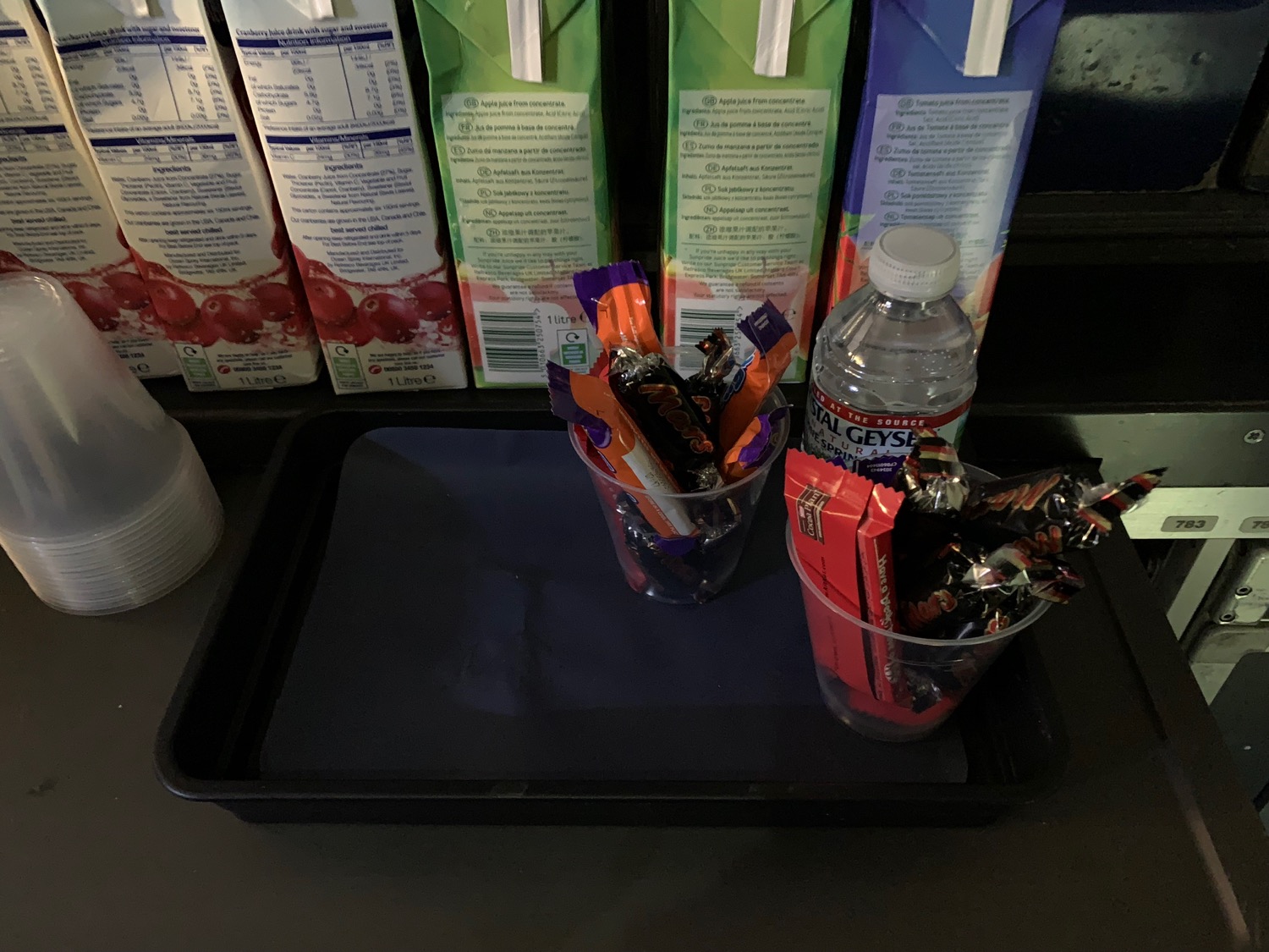 a tray with a plastic cup of candy and a bottle of water