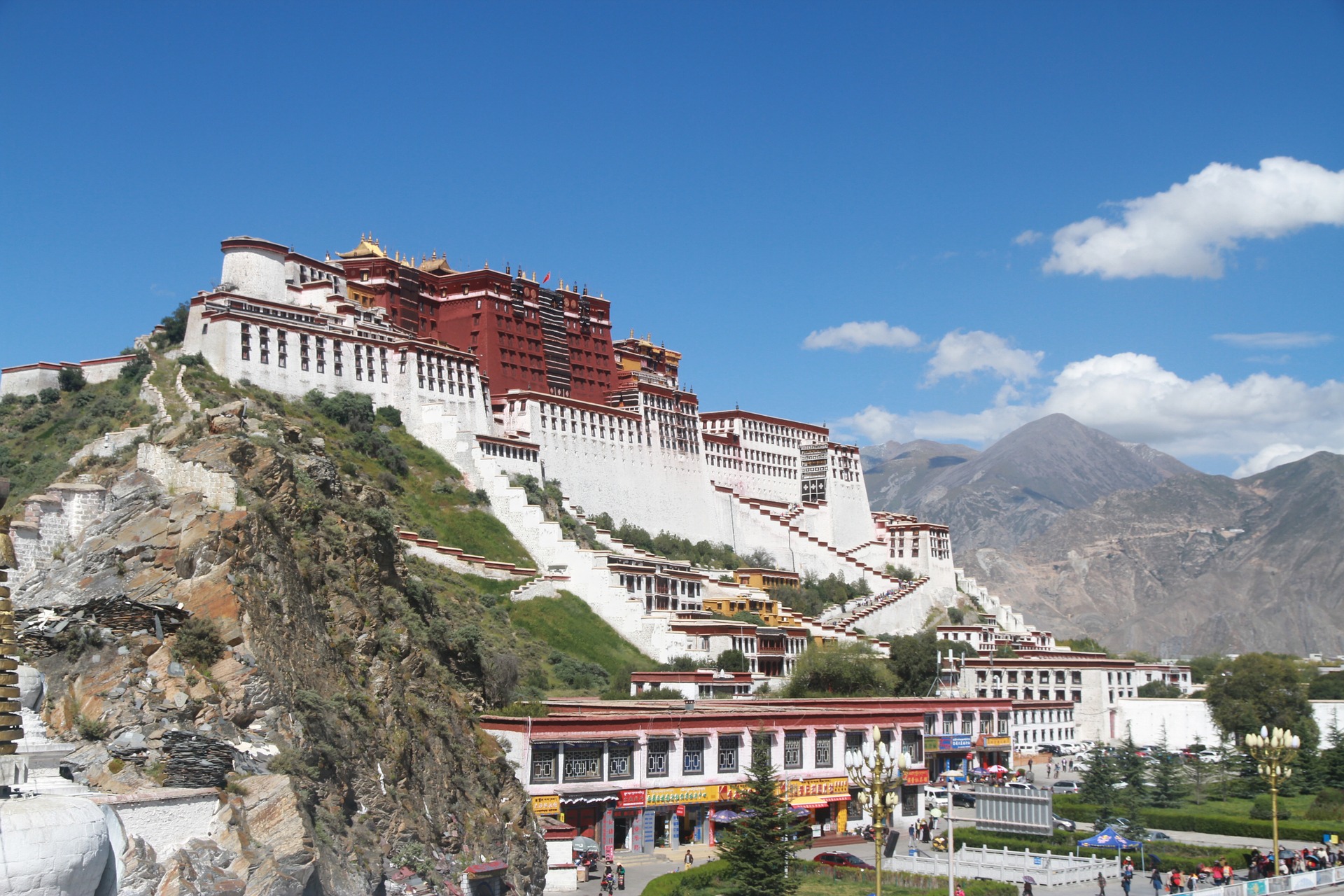 a white building on a hill with Potala Palace in the background