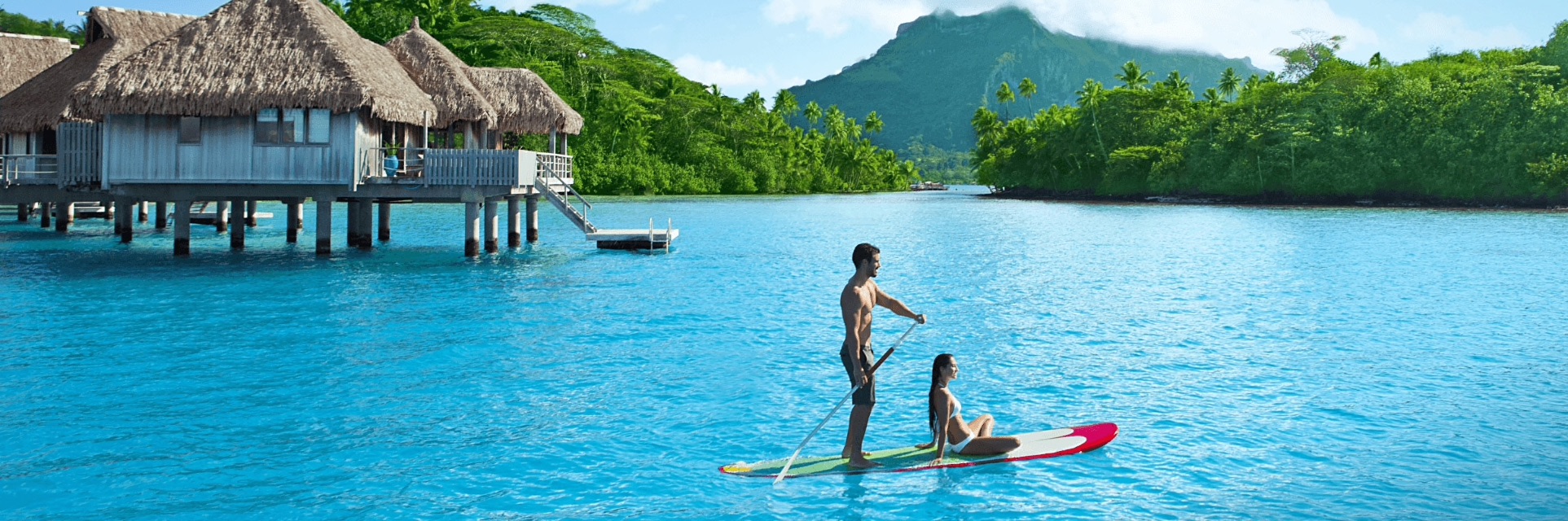 a man and woman on a paddle board in water
