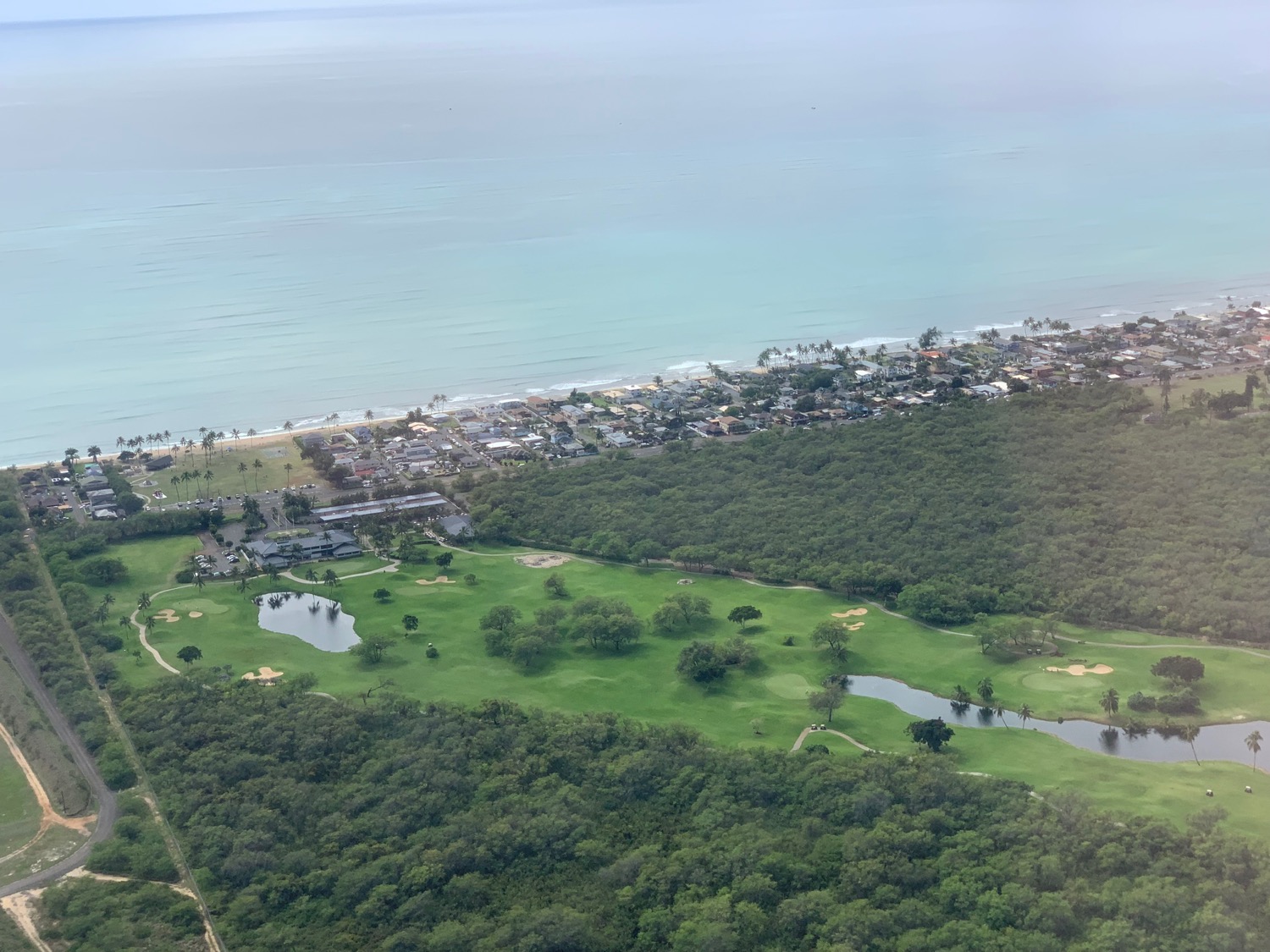 a aerial view of a golf course and a beach