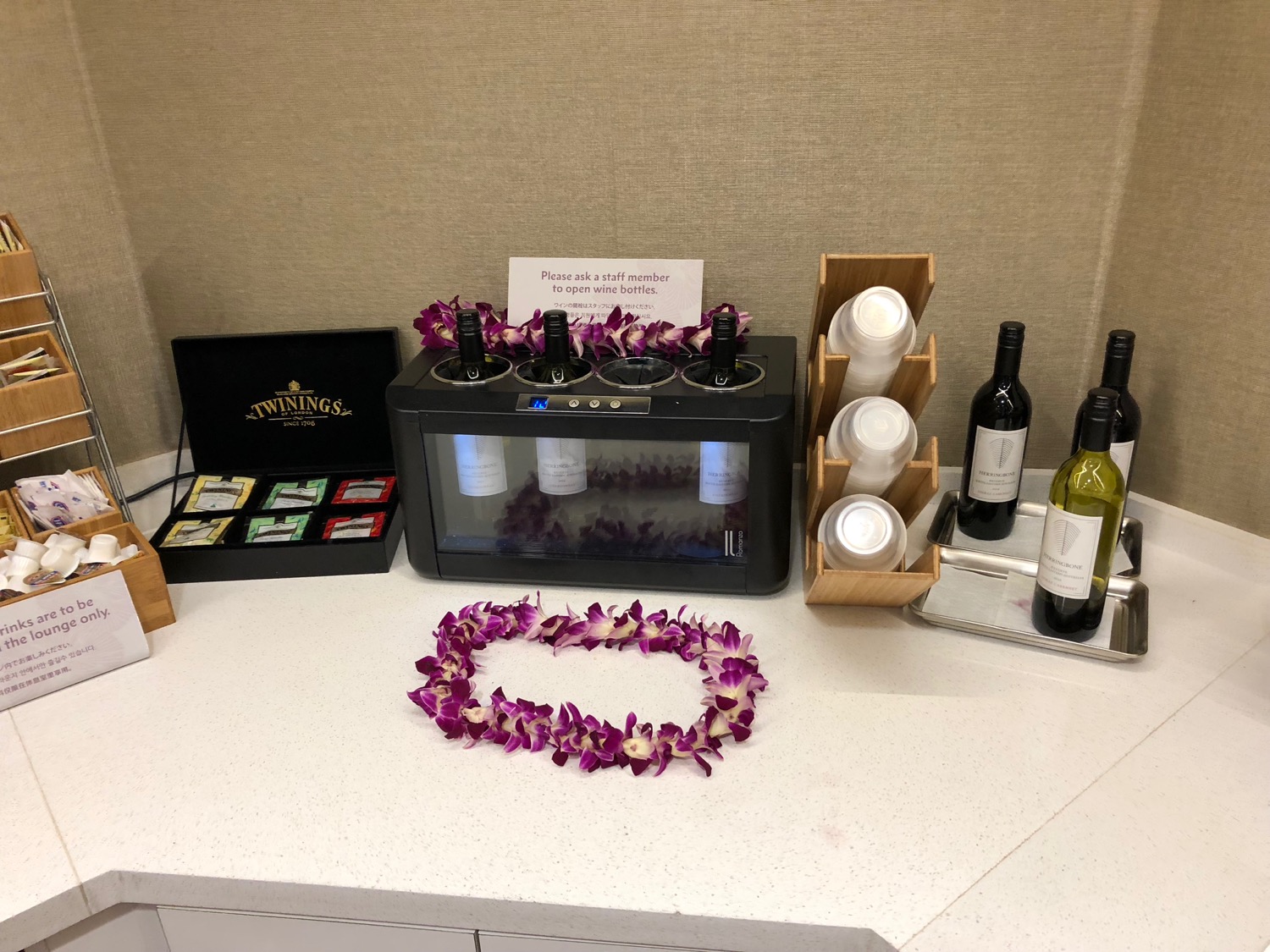 a table with wine bottles and a flower garland