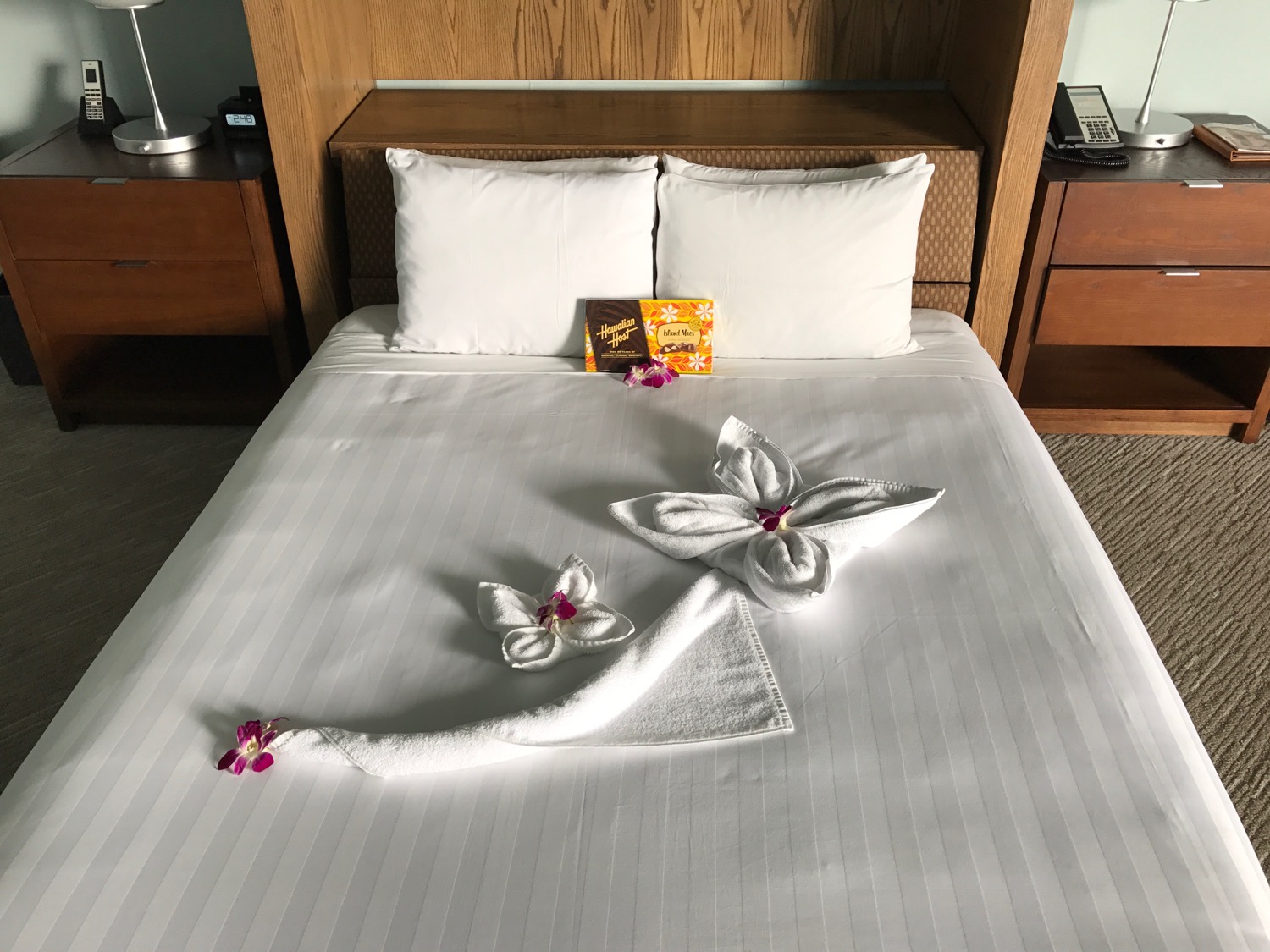 a bed with white towels and flowers on it