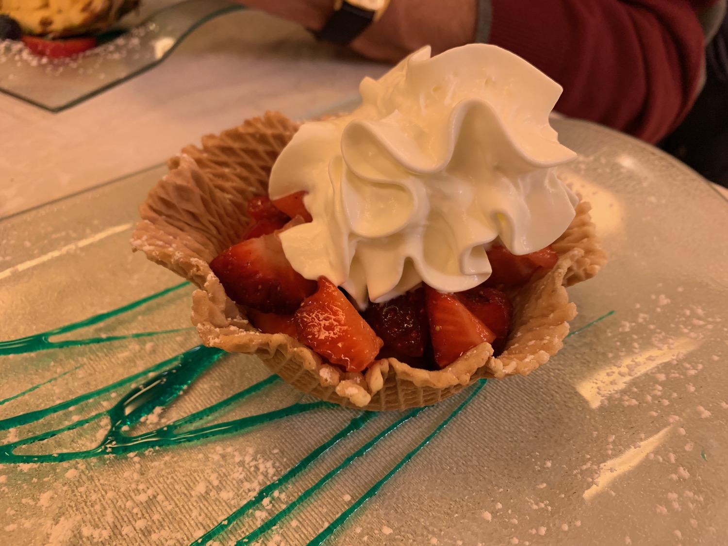 a strawberries and whipped cream in a waffle bowl