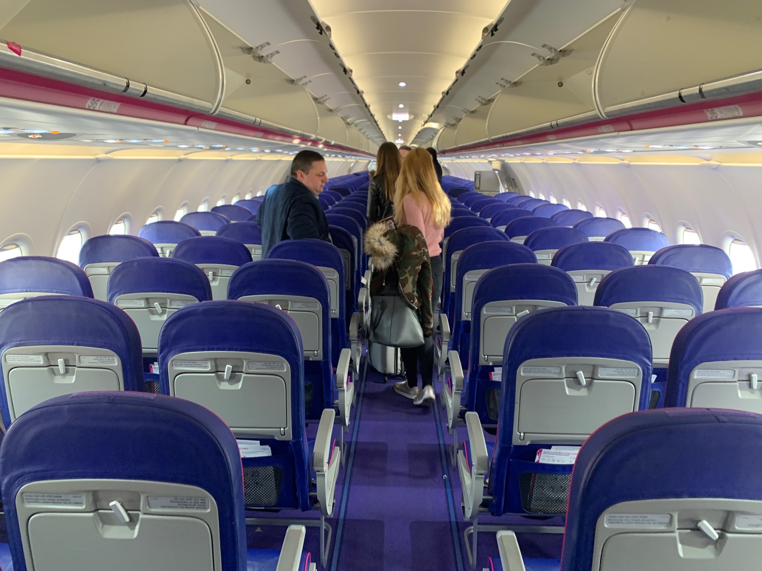 people in an airplane with blue seats