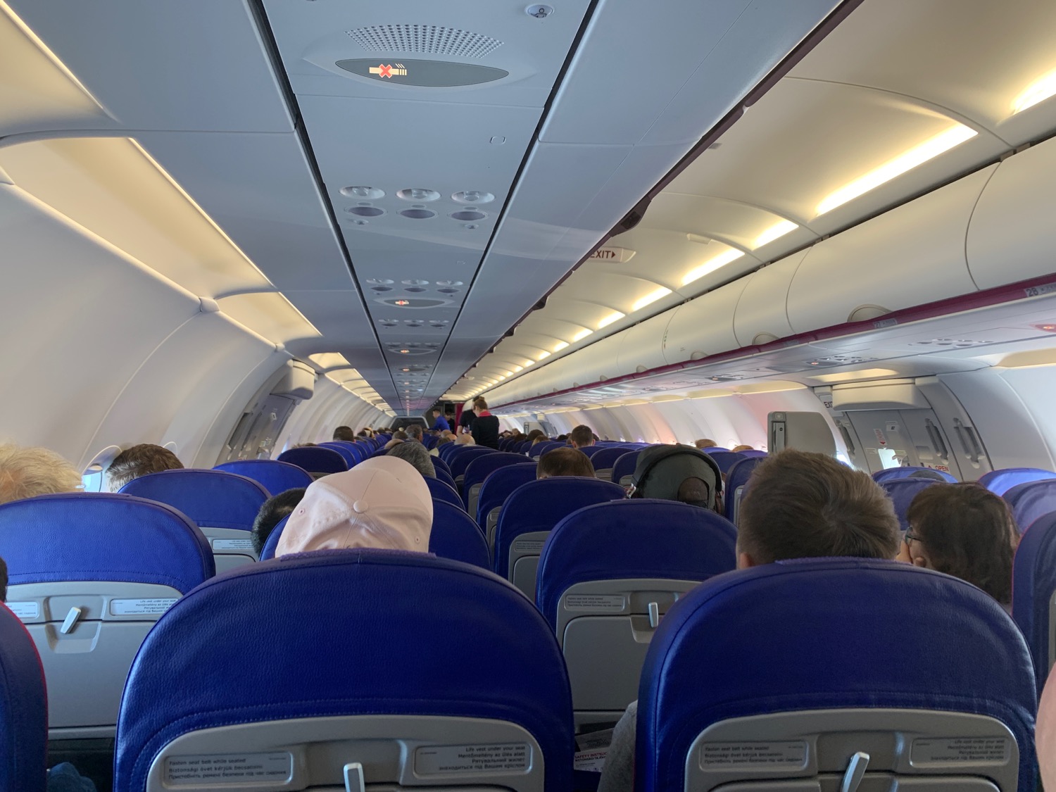 a plane with blue seats and people sitting on it
