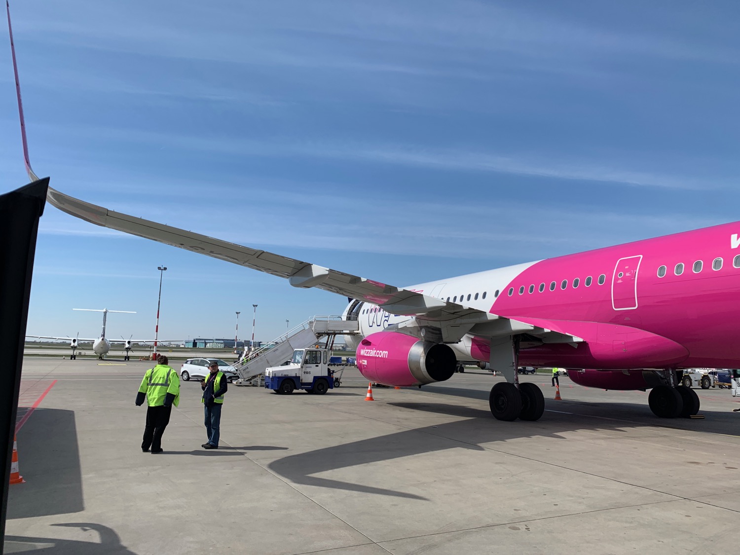 a pink and white airplane on a tarmac