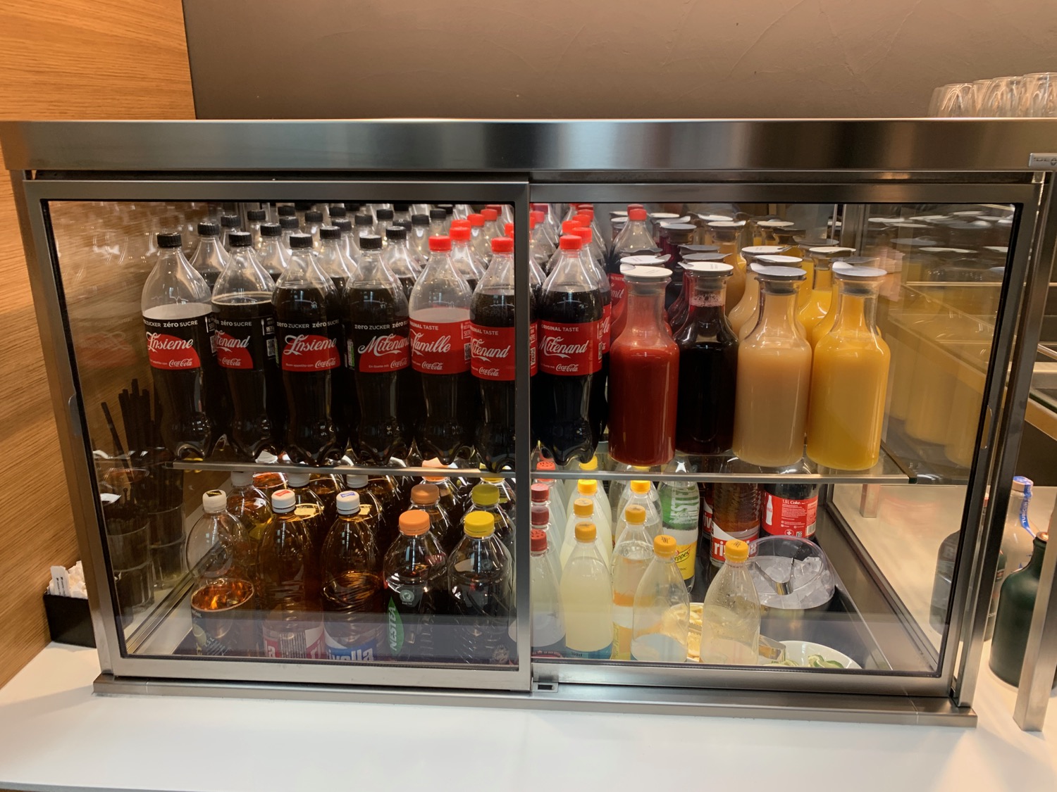 a display case with bottles of soda and other beverages