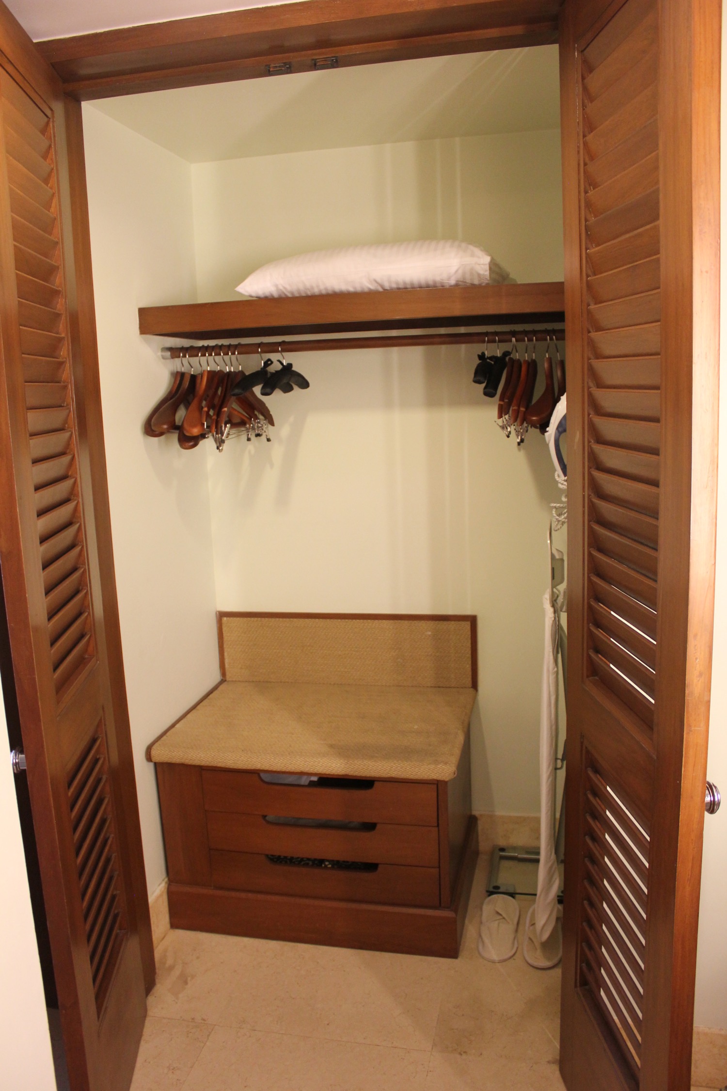 a closet with a shelf and swingers