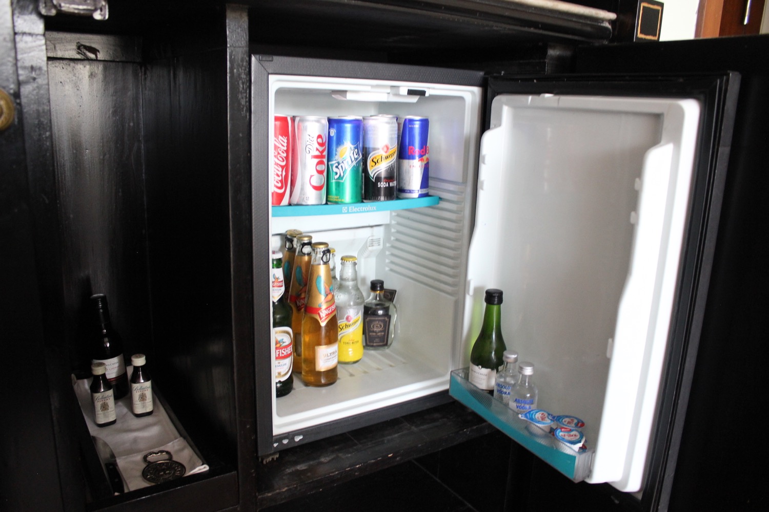 a mini fridge with bottles of beer and bottles of alcohol