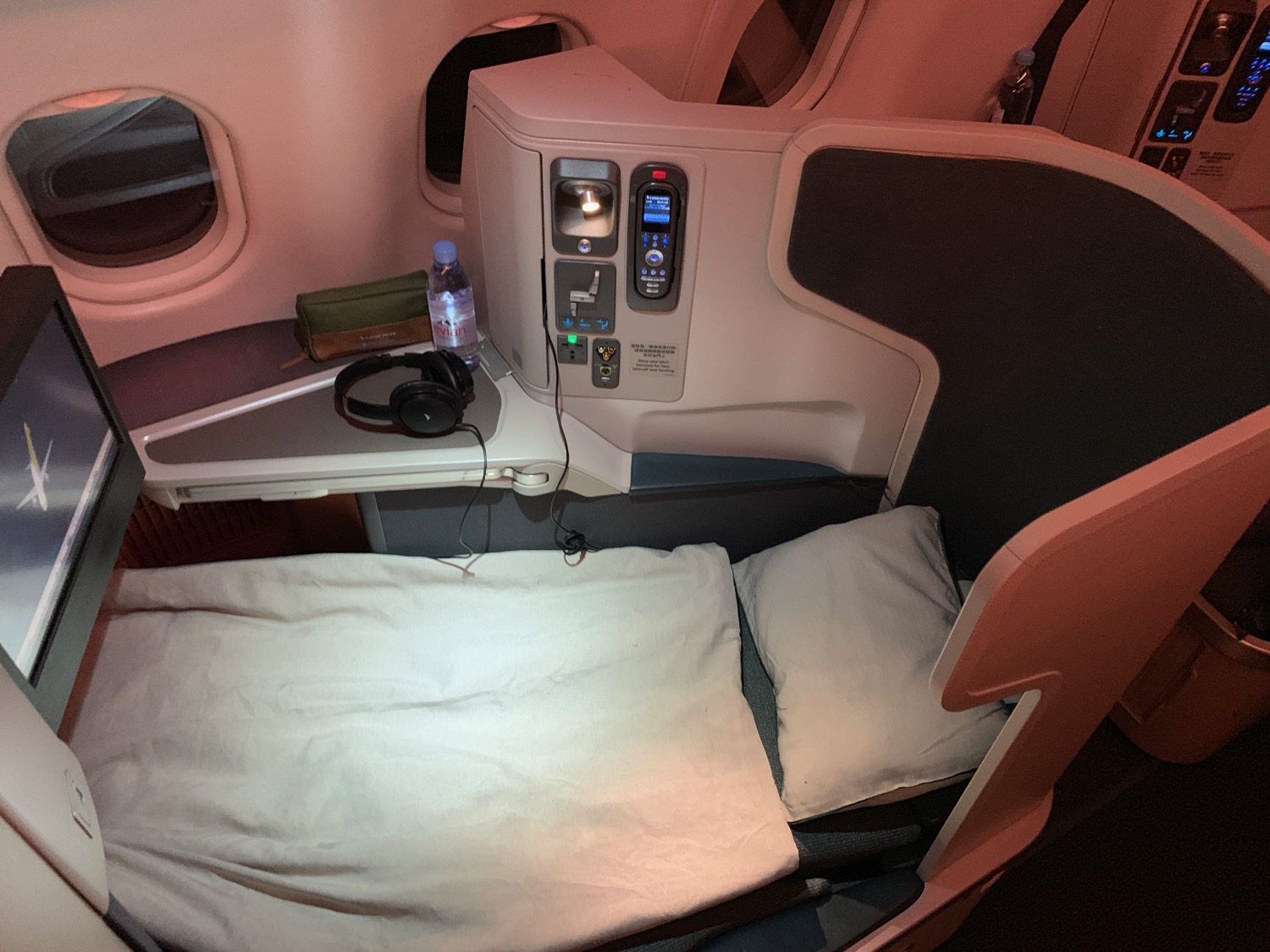 a bed with headphones and a pillow on a table in a plane