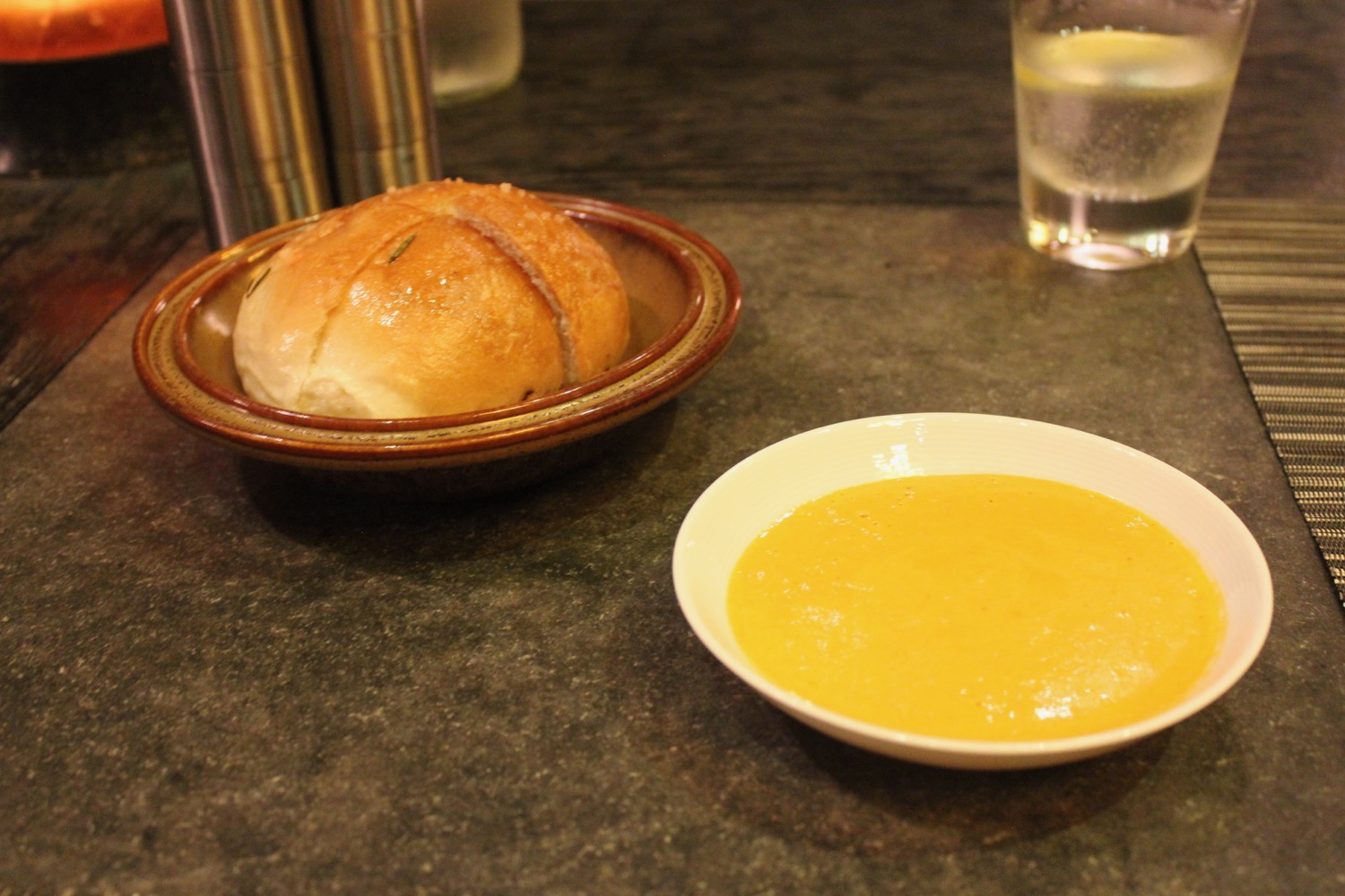 a bowl of soup and a bread on a table