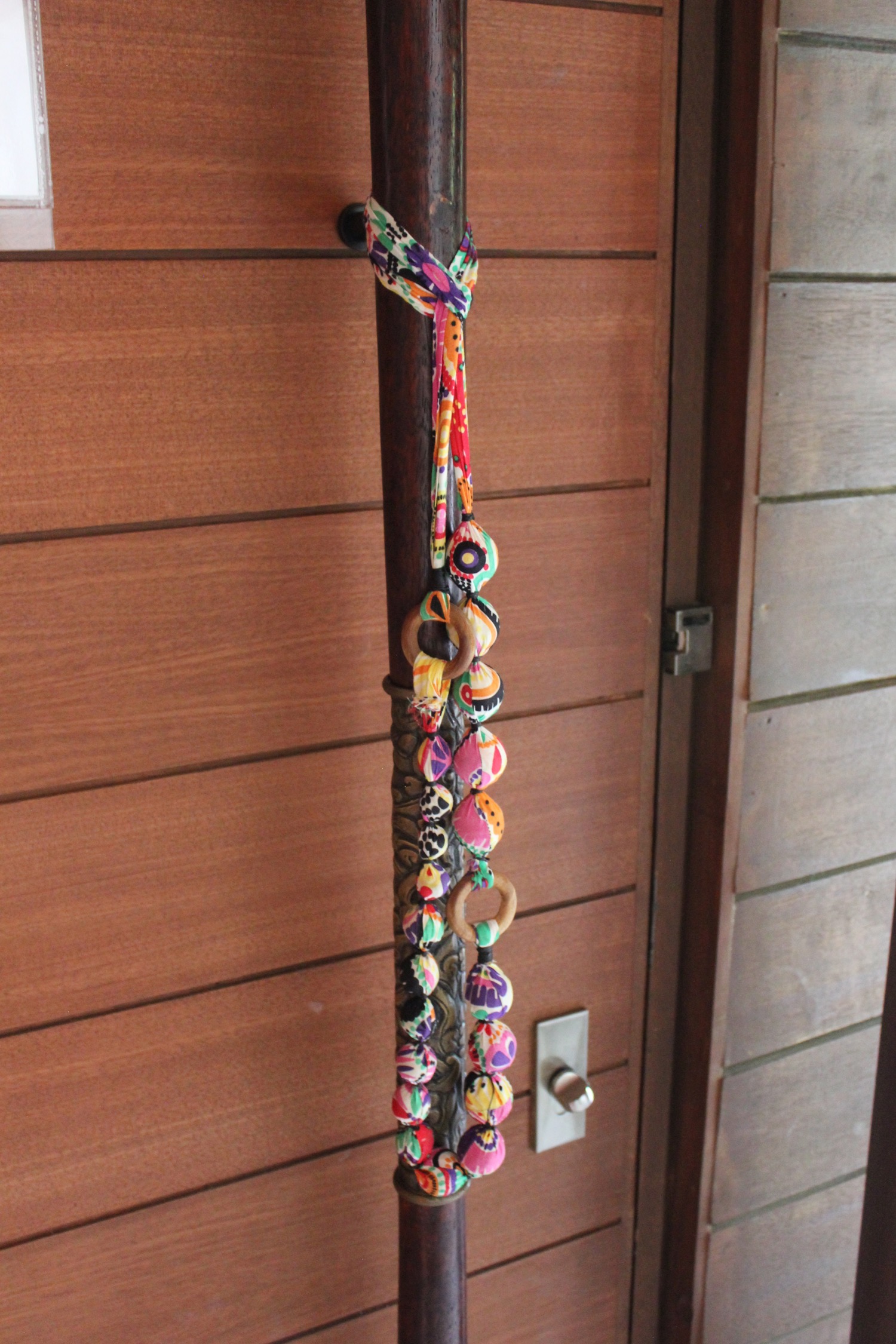 a wooden pole with colorful necklaces on it