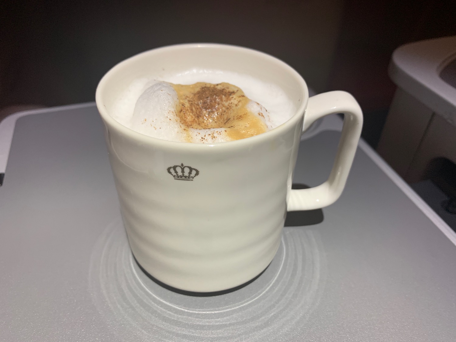 a white mug with a brown foamy top