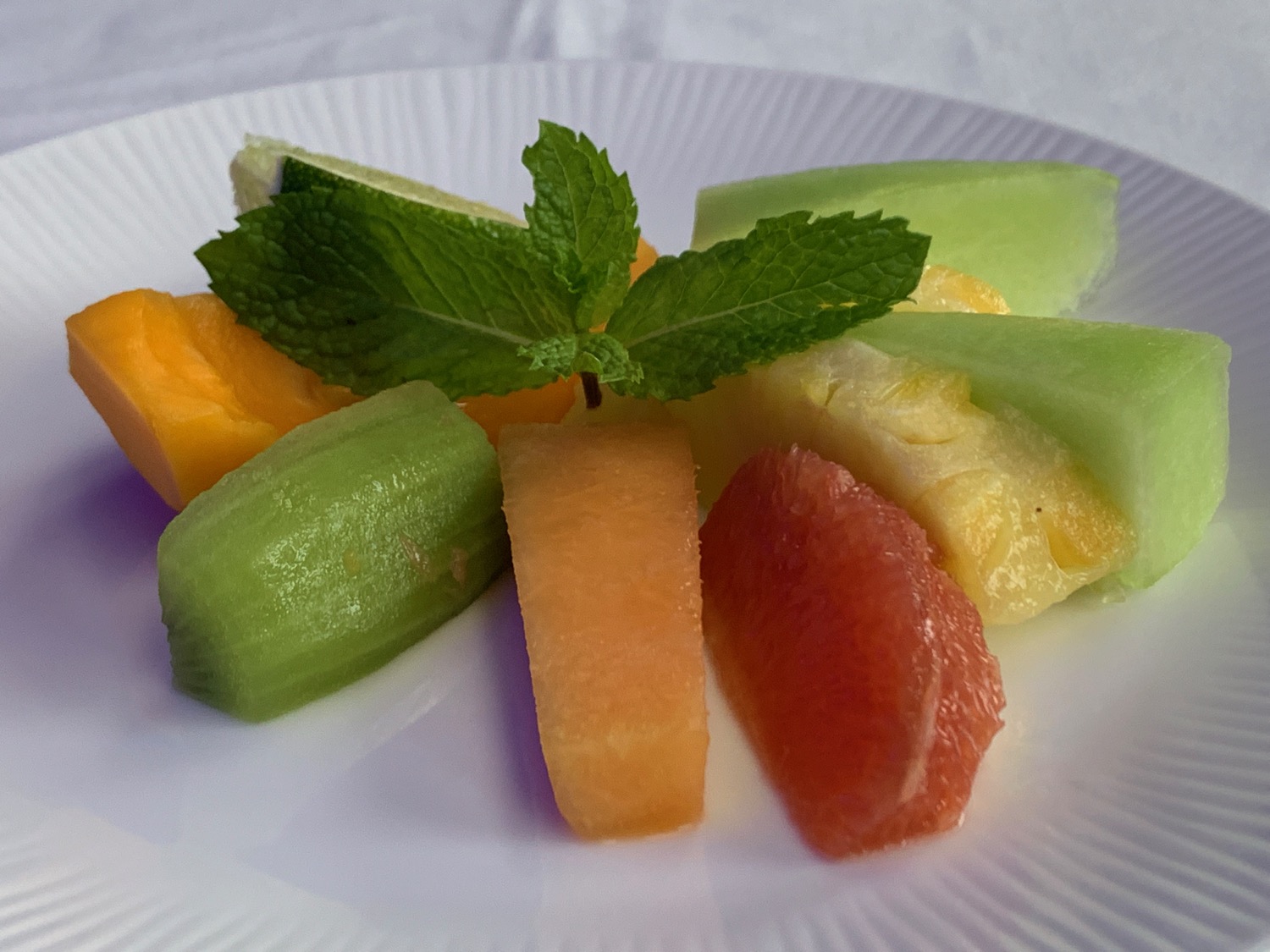 a plate of fruit on a white surface