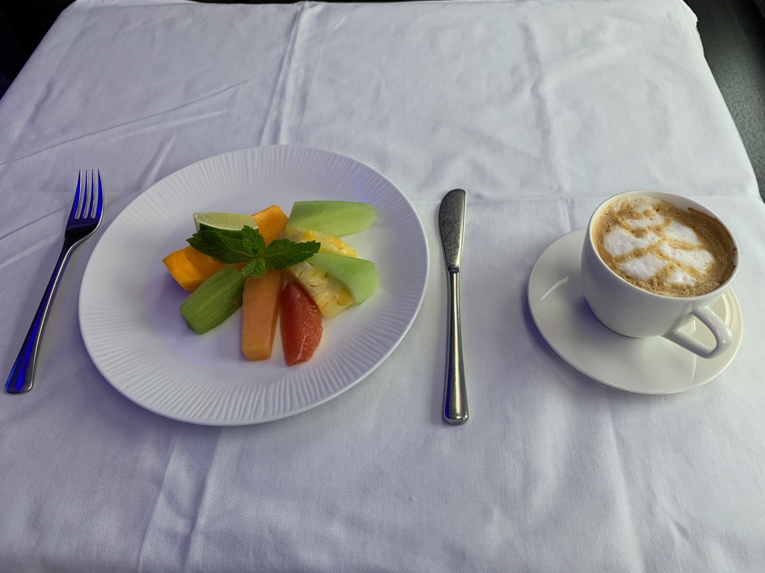 a plate of fruit and a cup of coffee