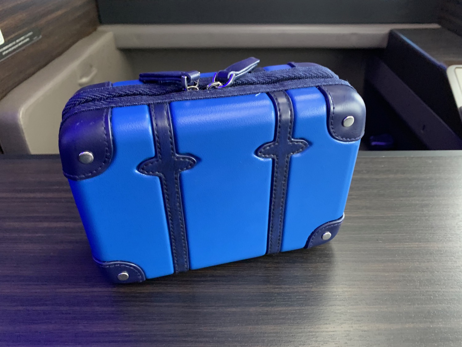 a blue and black suitcase on a wood surface