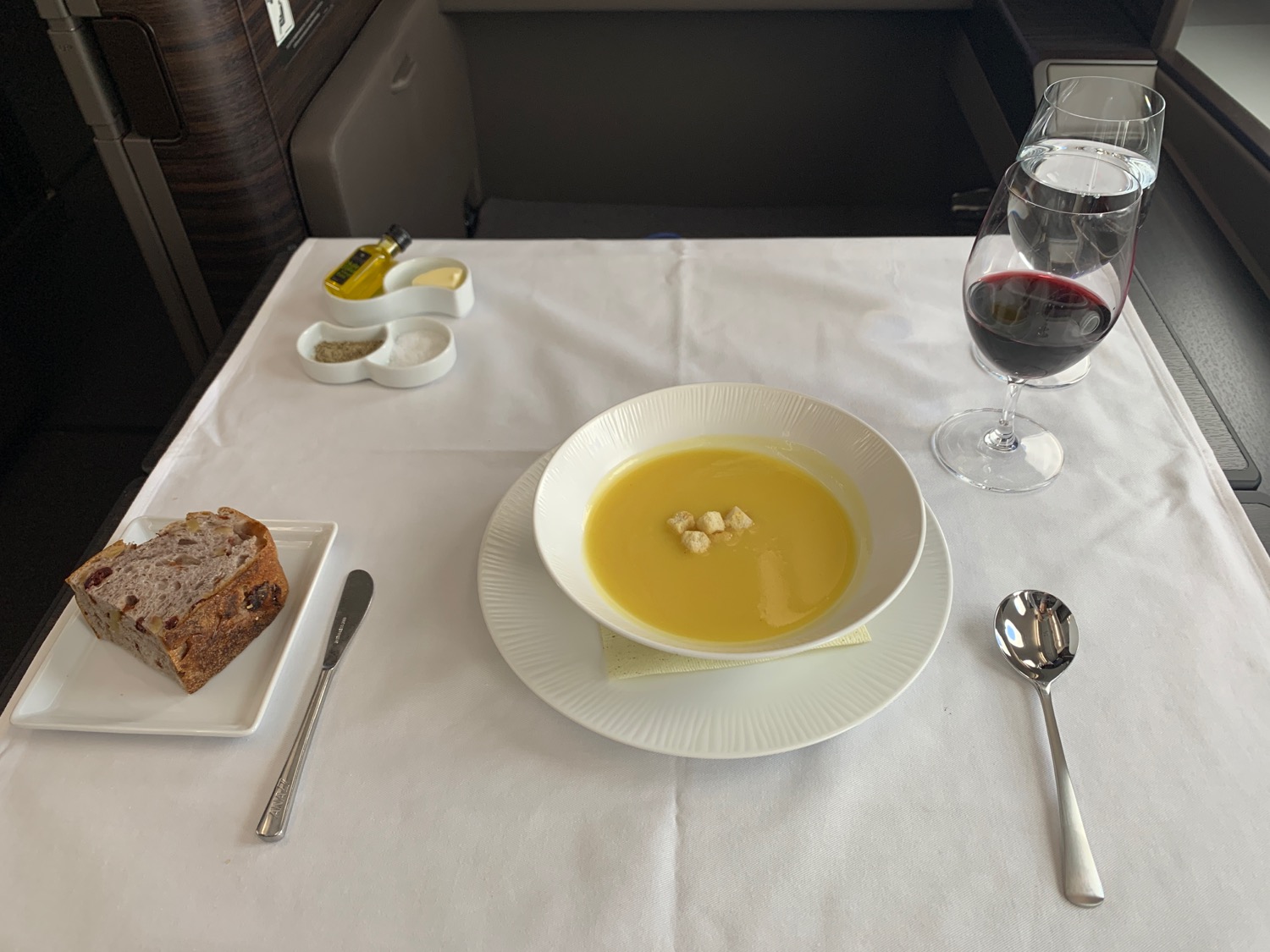 a plate of soup and a glass of wine on a table