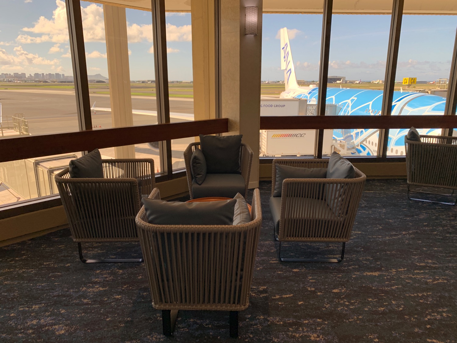 a group of chairs in a room with windows and a plane in the background