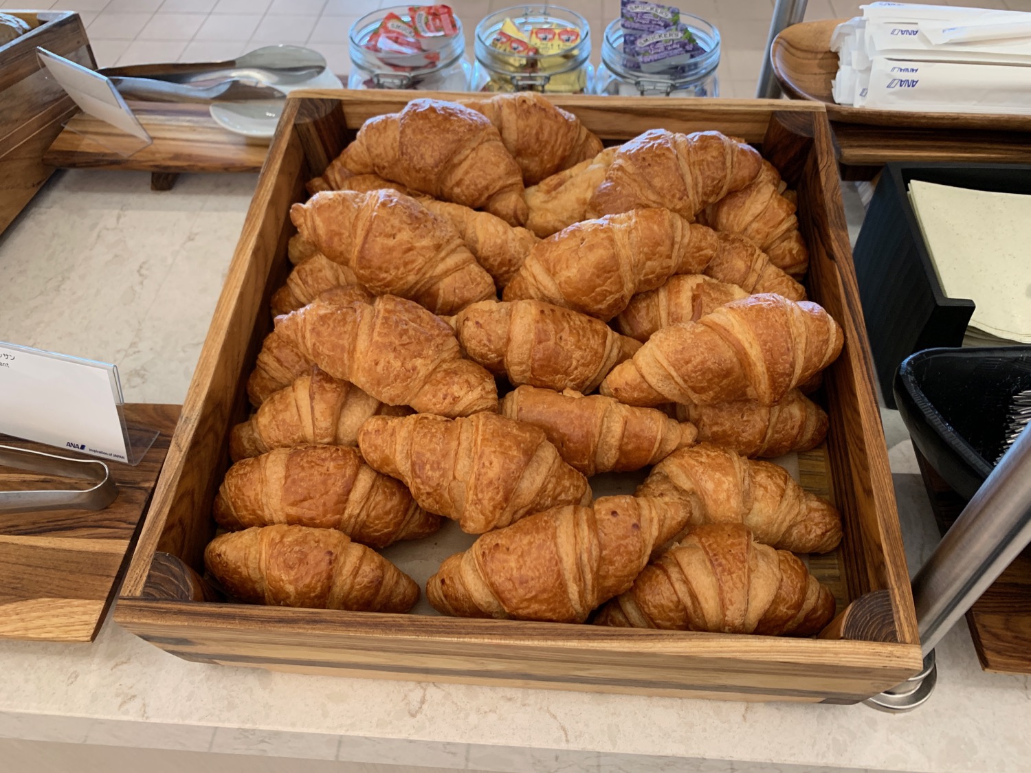 a wooden tray of croissants