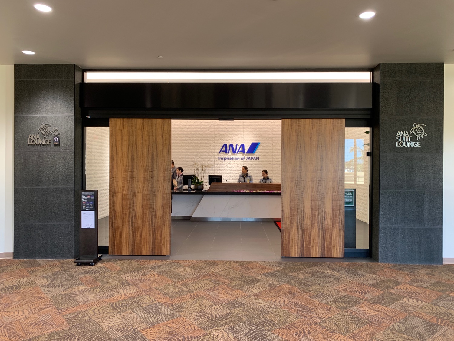a lobby with a reception desk and people in it