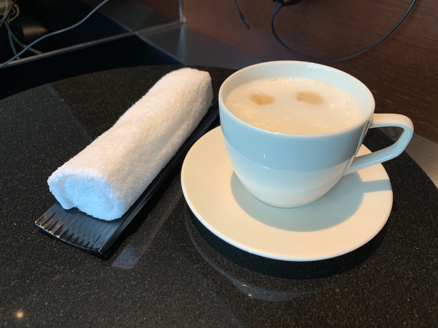 a cup of coffee and a towel on a plate