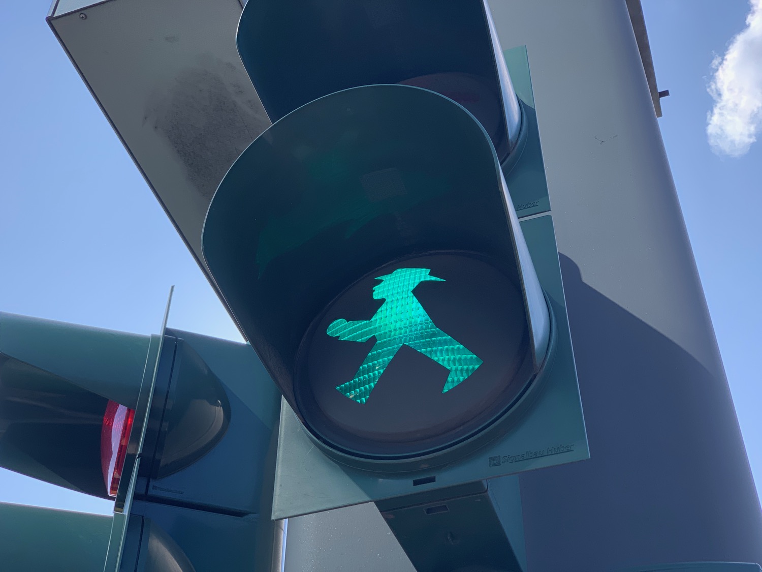 a green traffic light with a man walking symbol