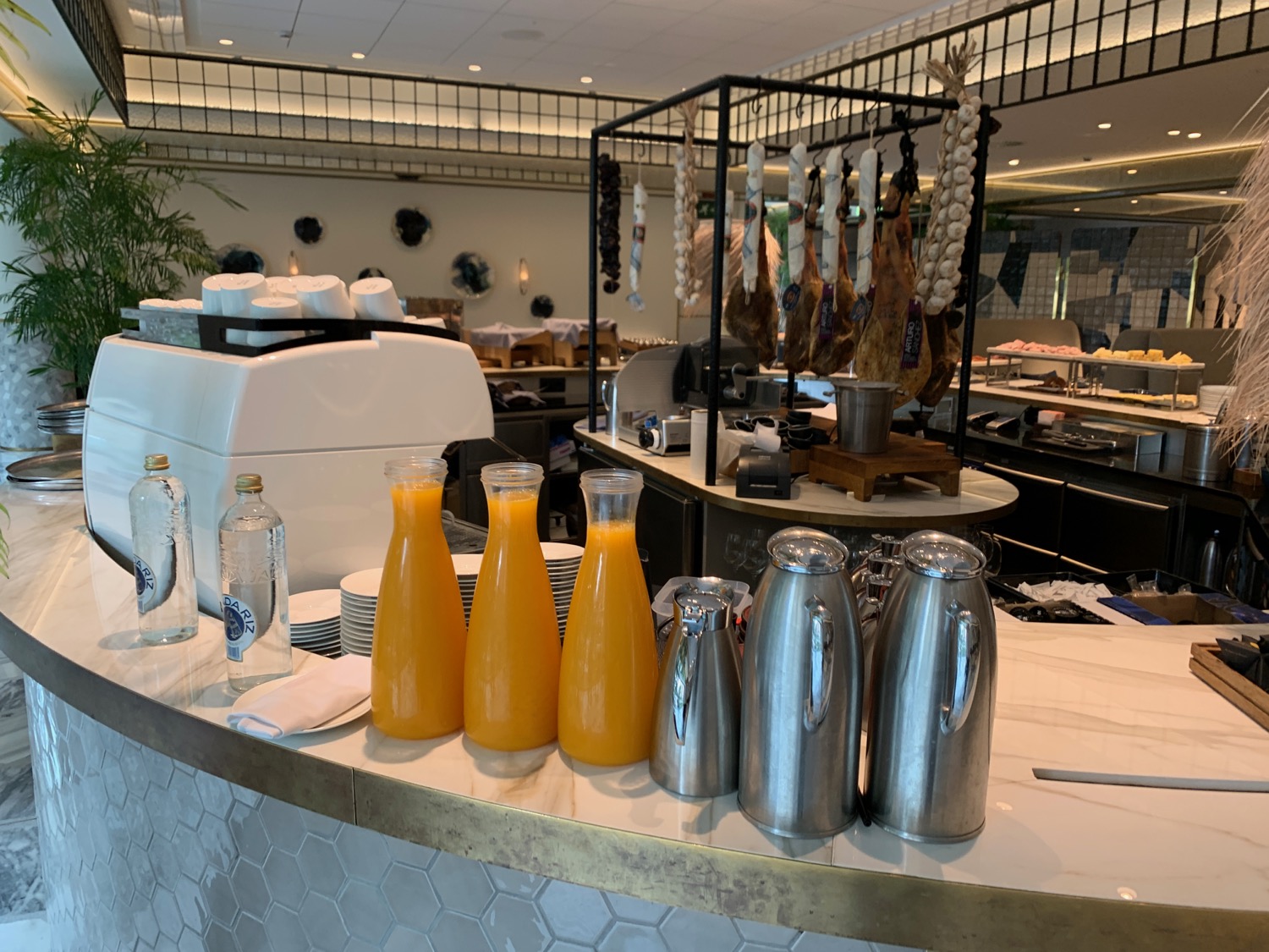 a counter with a group of bottles of orange juice and silver containers