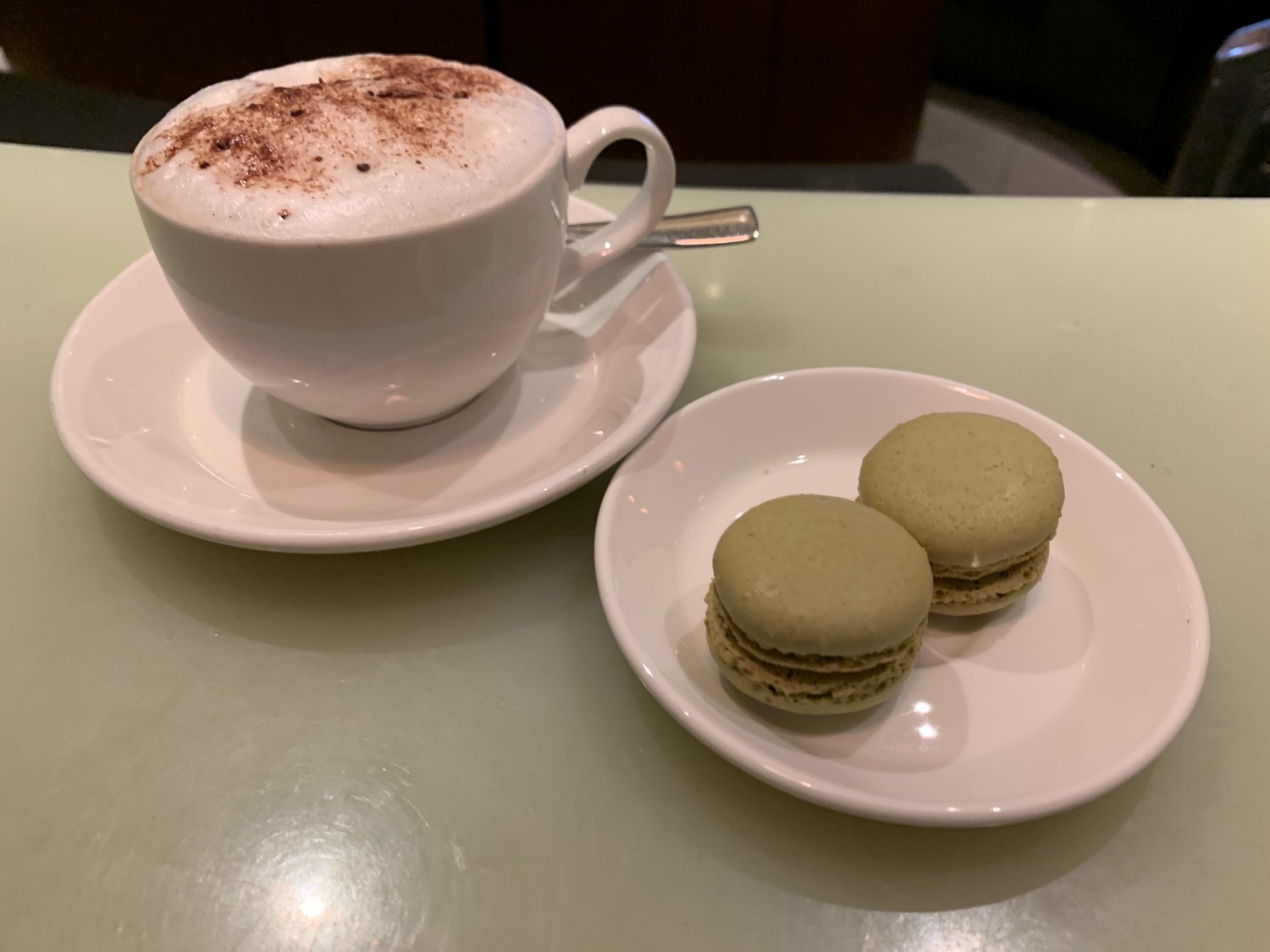 a cup of coffee and two cookies on a saucer