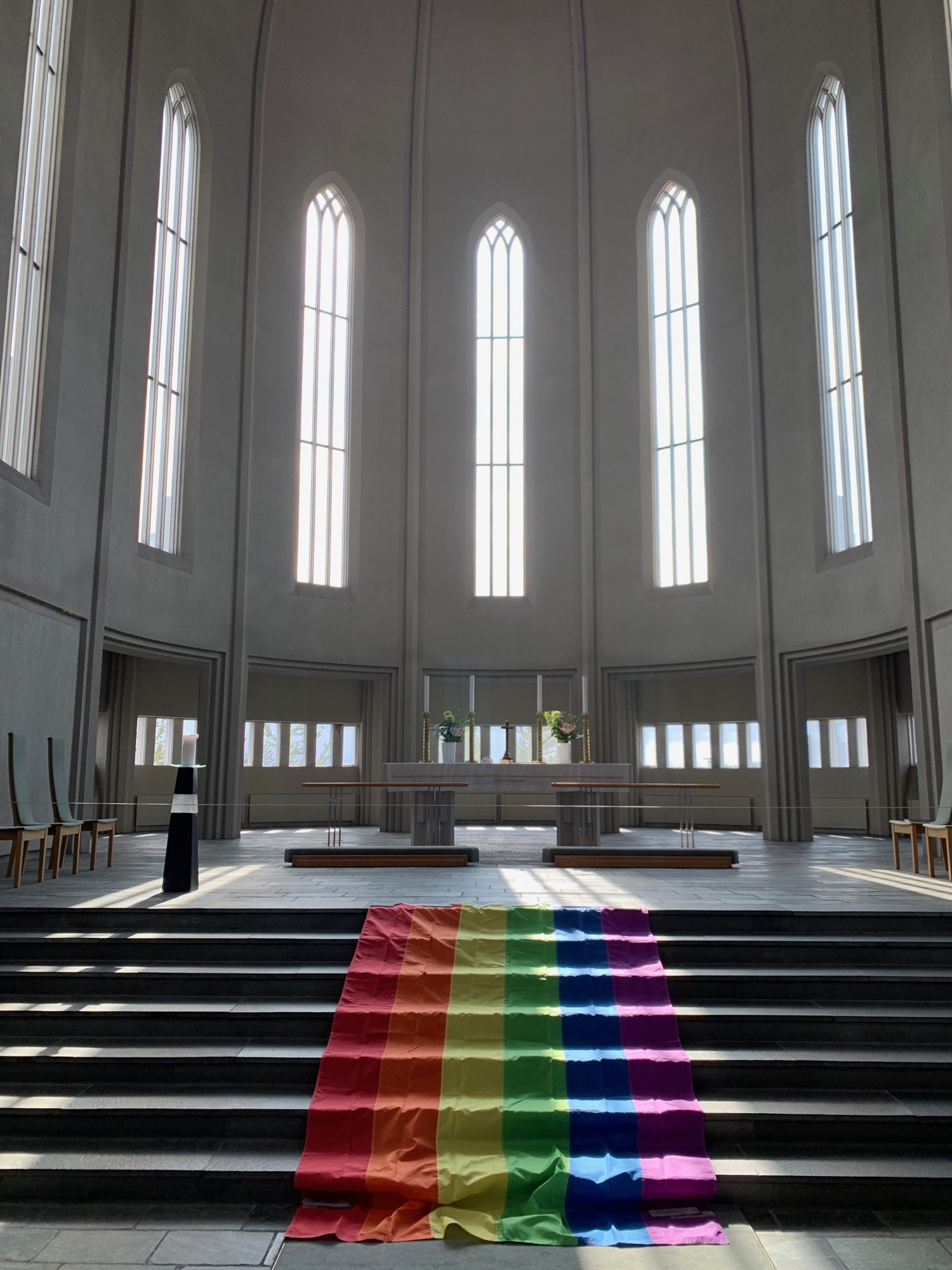 a rainbow flag on a staircase in a church