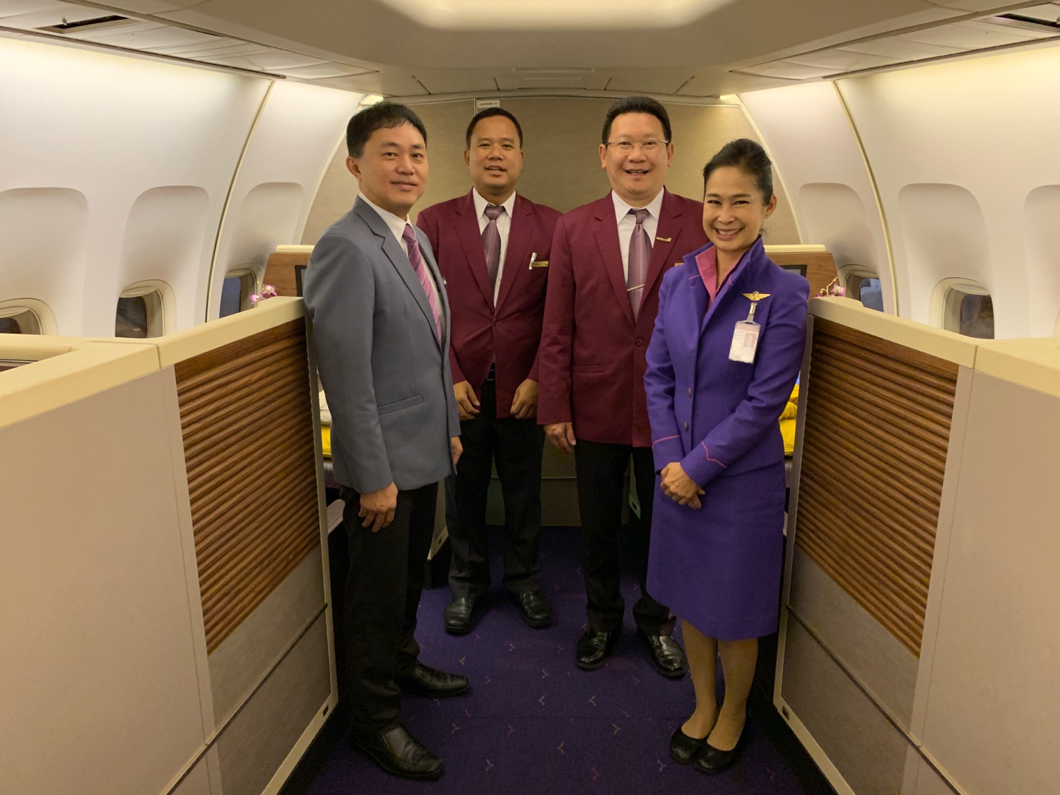 a group of people standing in a room of an airplane