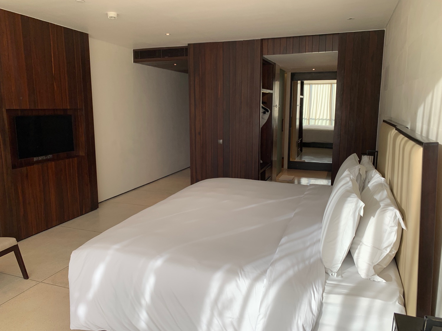 a bed with white sheets and a wood paneled wall