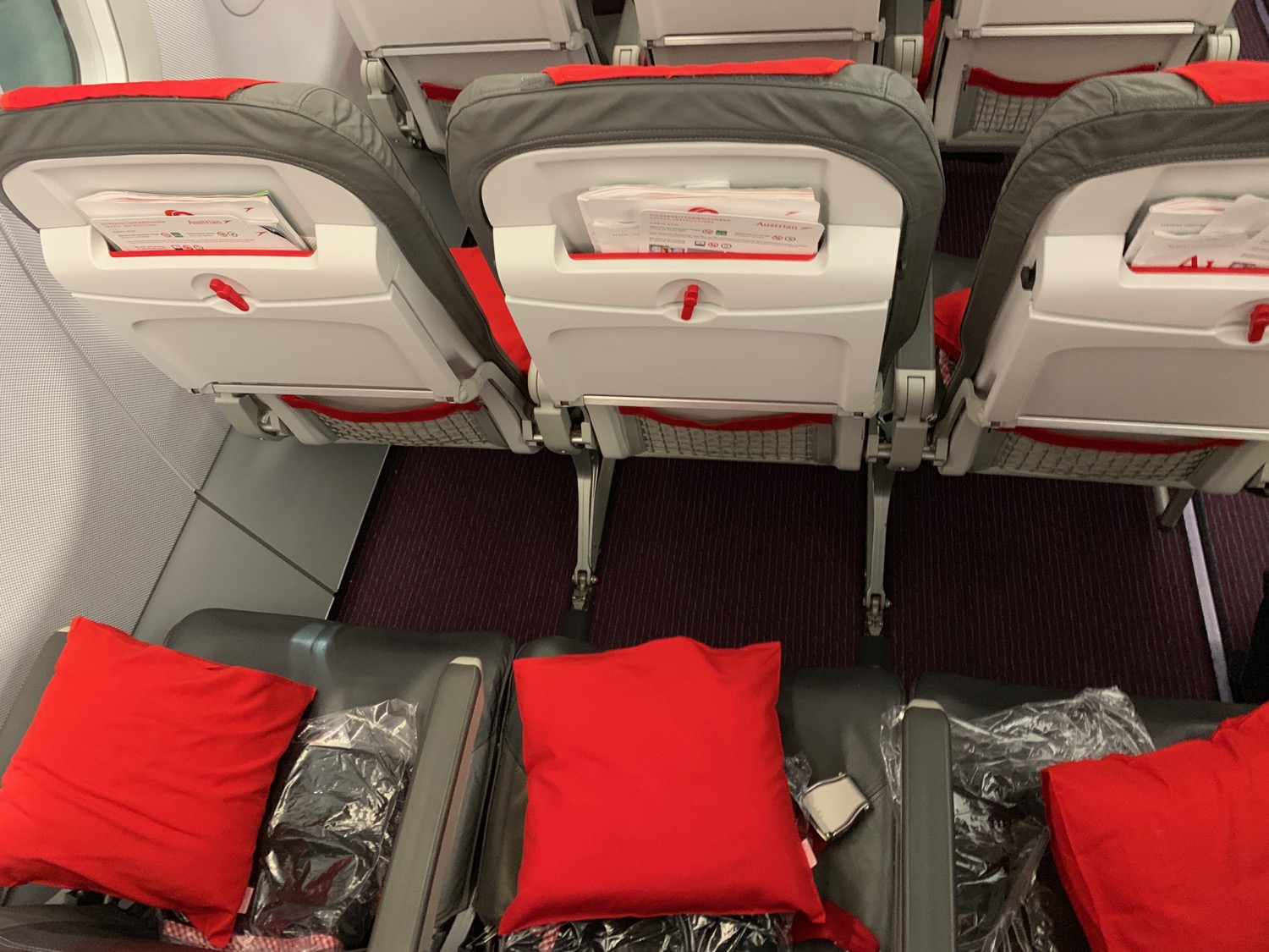 a row of seats with red pillows