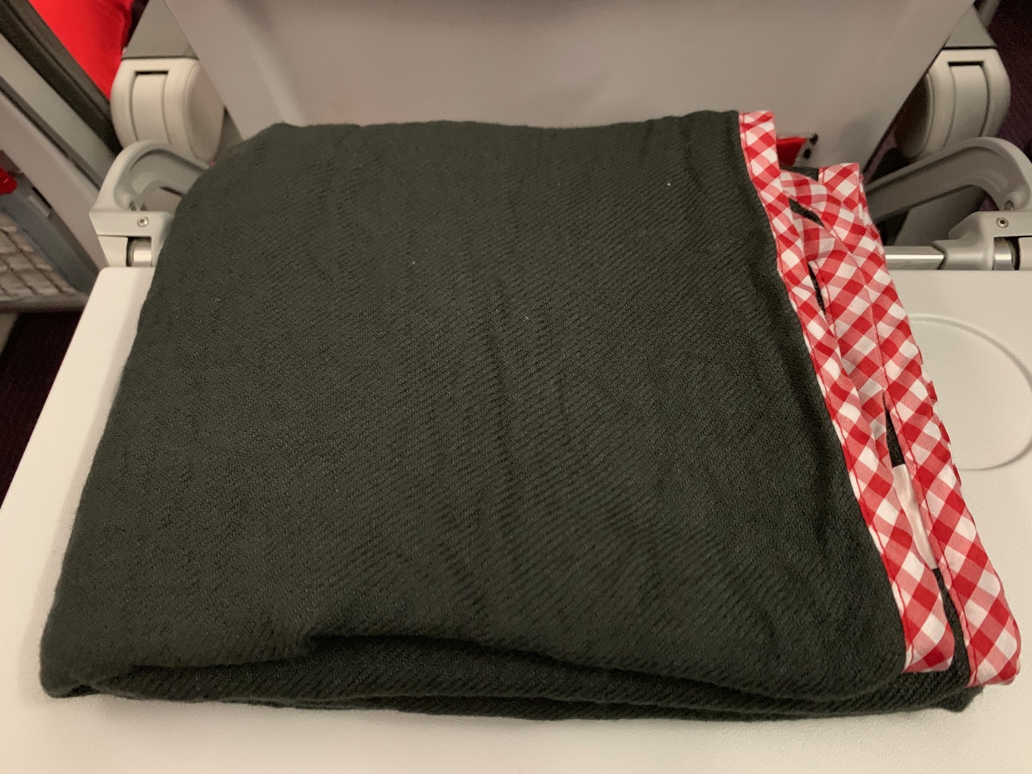a black blanket with red and white checkered trim